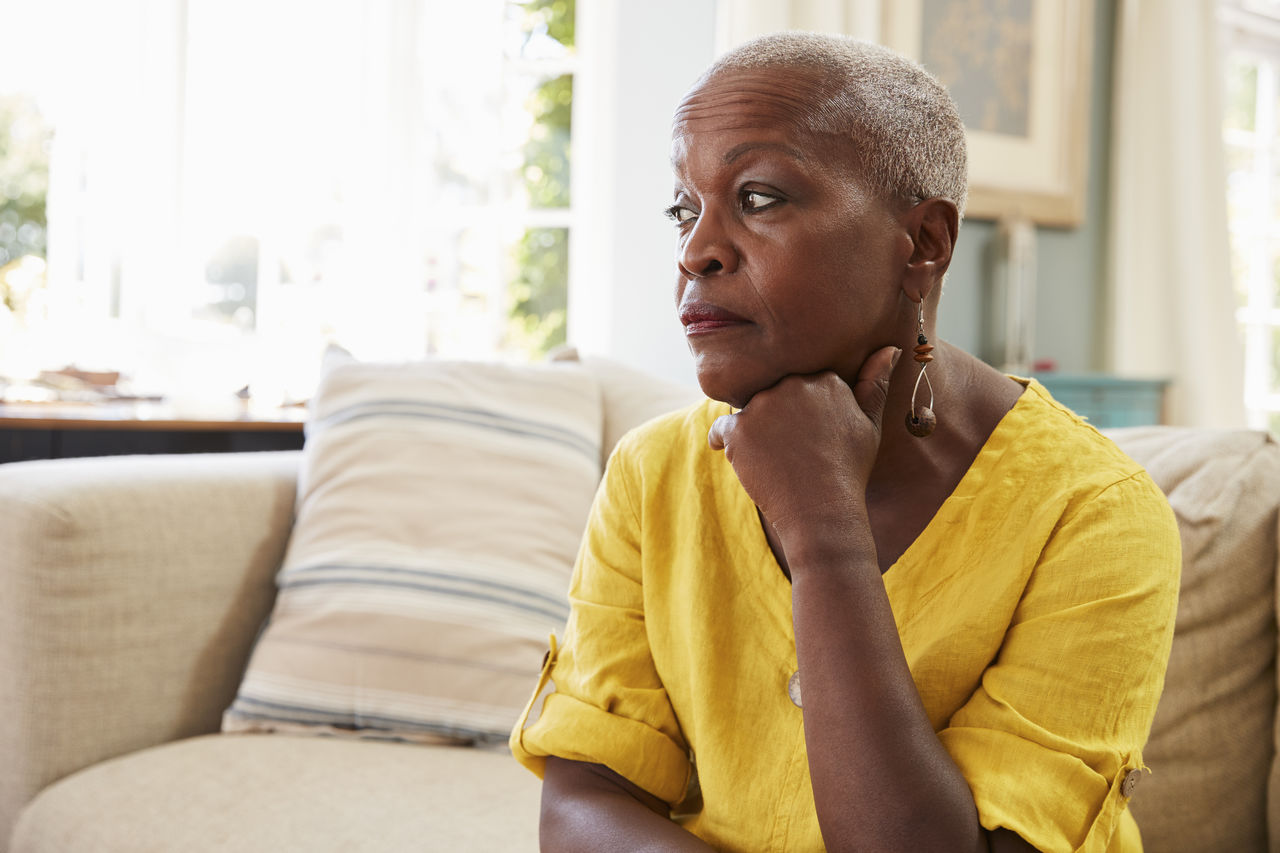 Senior Woman Sitting On Sofa At Home Suffering From Depression_large.jpg