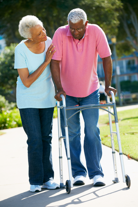 Senior Woman Helping Husband With Walking Frame