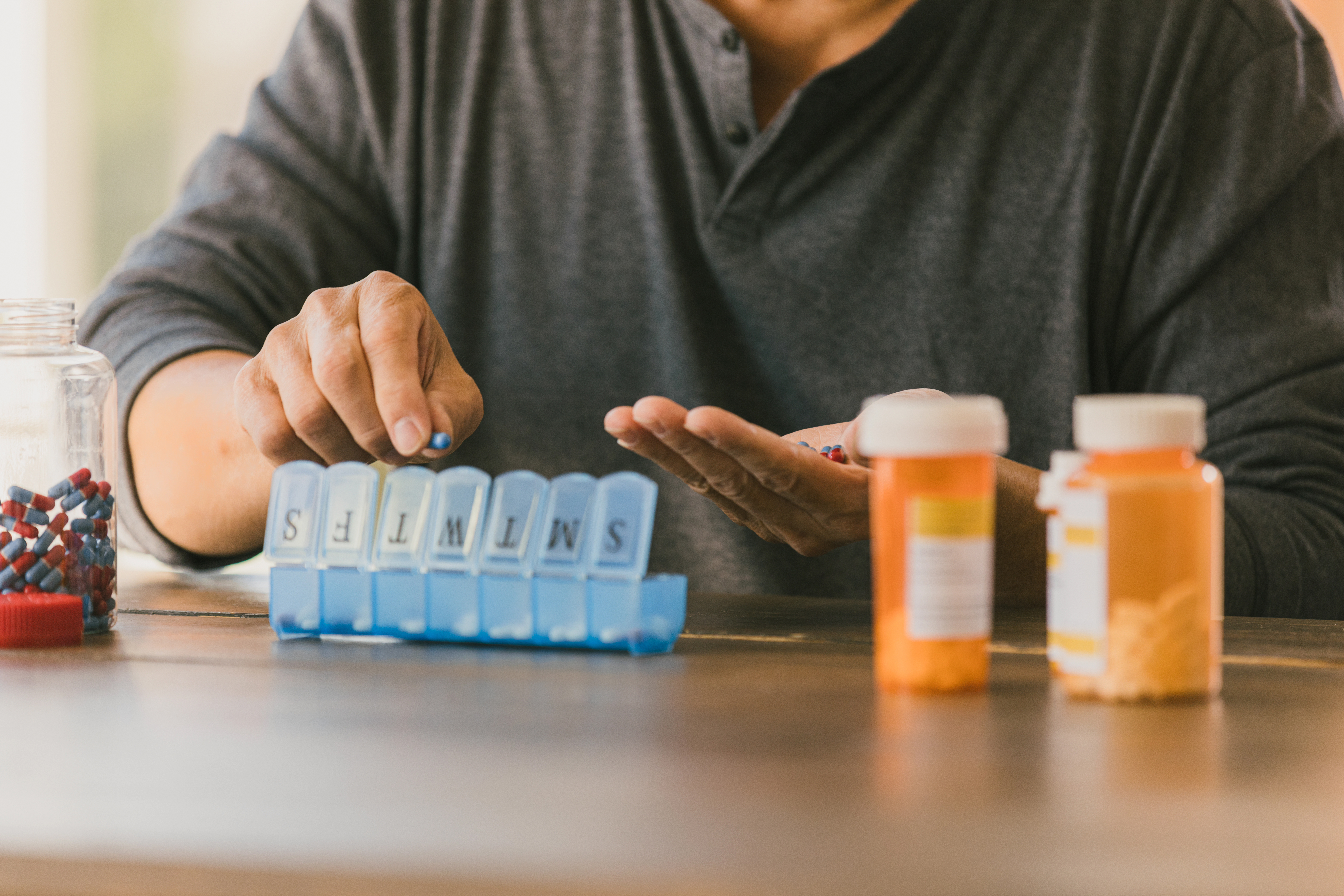 Unrecognizable senior man organizes medication