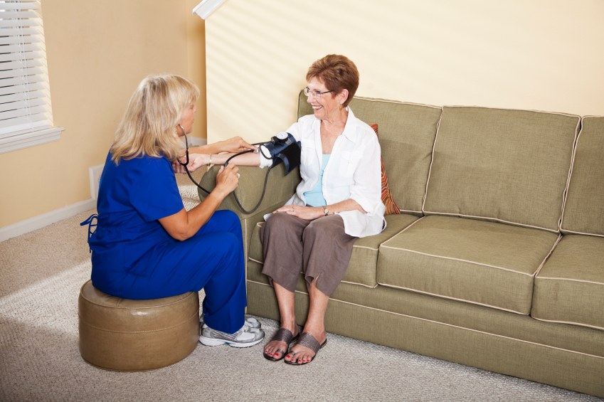 Nurse taking senior woman's blood pressure