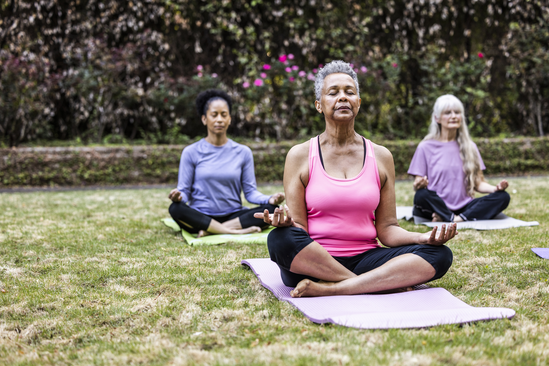 Senior women taking a yoga class in beautiful garden