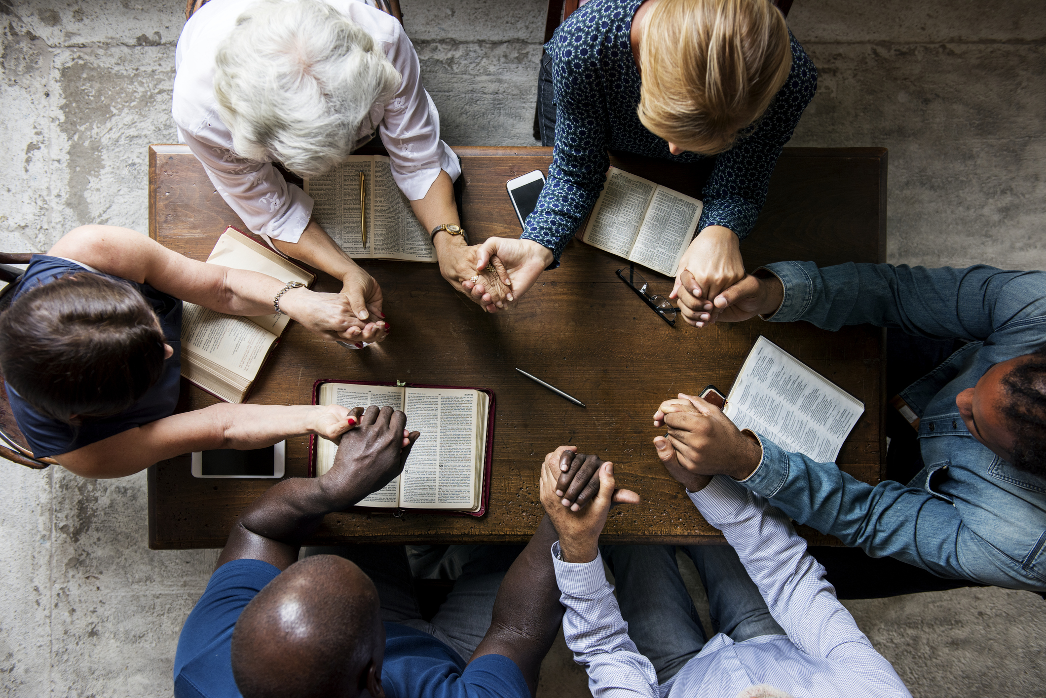 Group of people holding hands praying worship believe