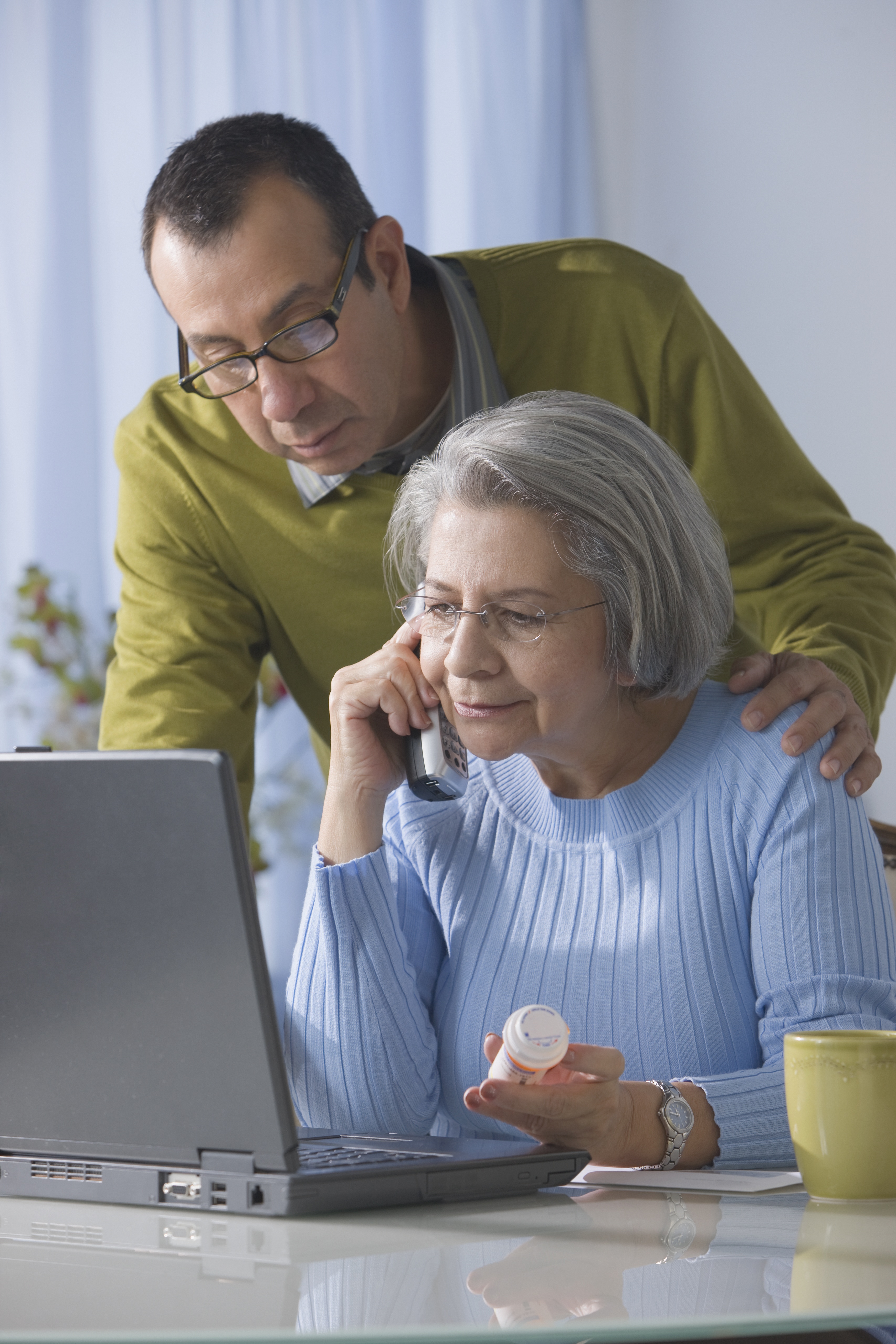 Senior Hispanic woman refilling drug prescription over the telephone