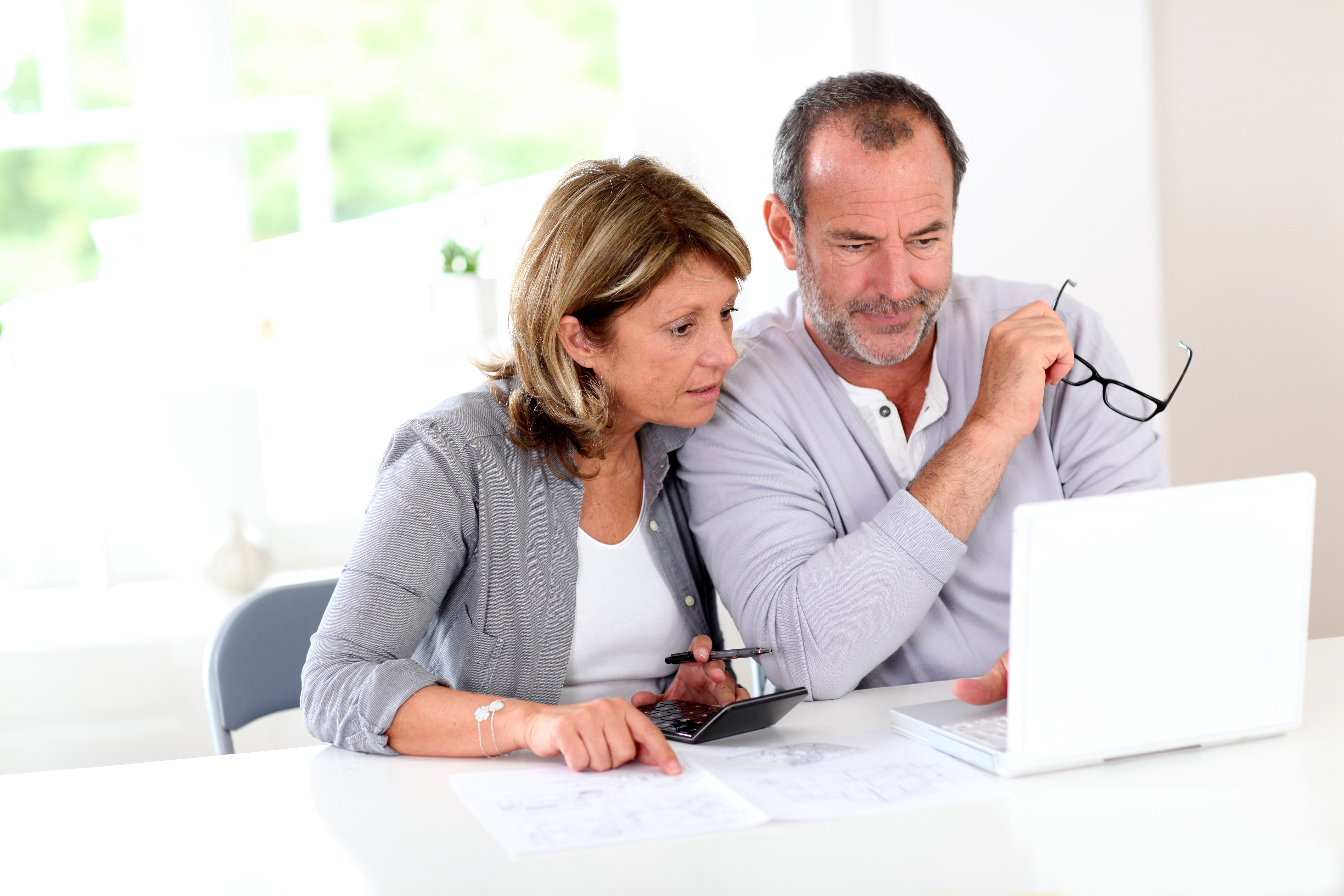 Senior couple using laptop at home