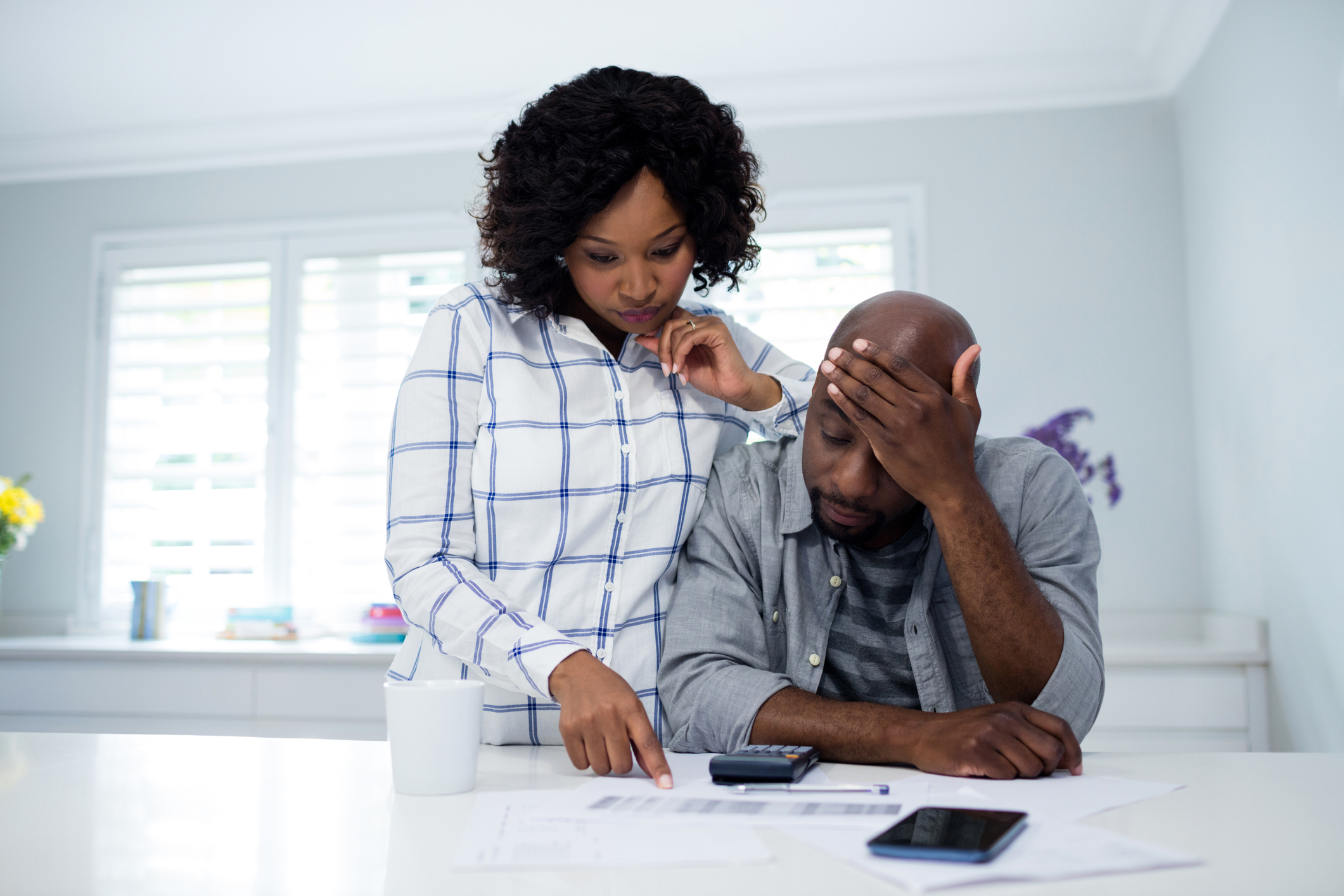 Worried couple interacting while checking the bills