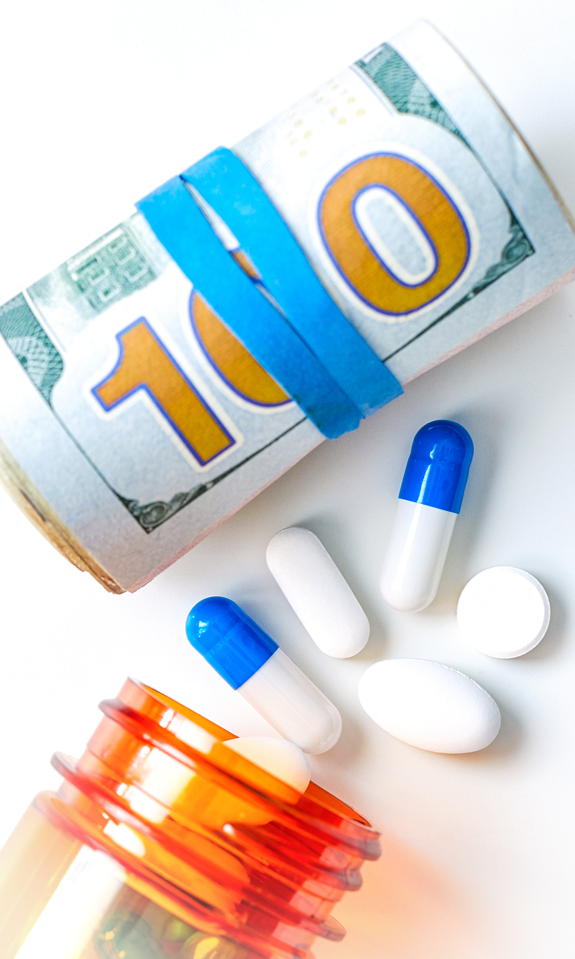 Close-up on various pills, capsules, bankroll