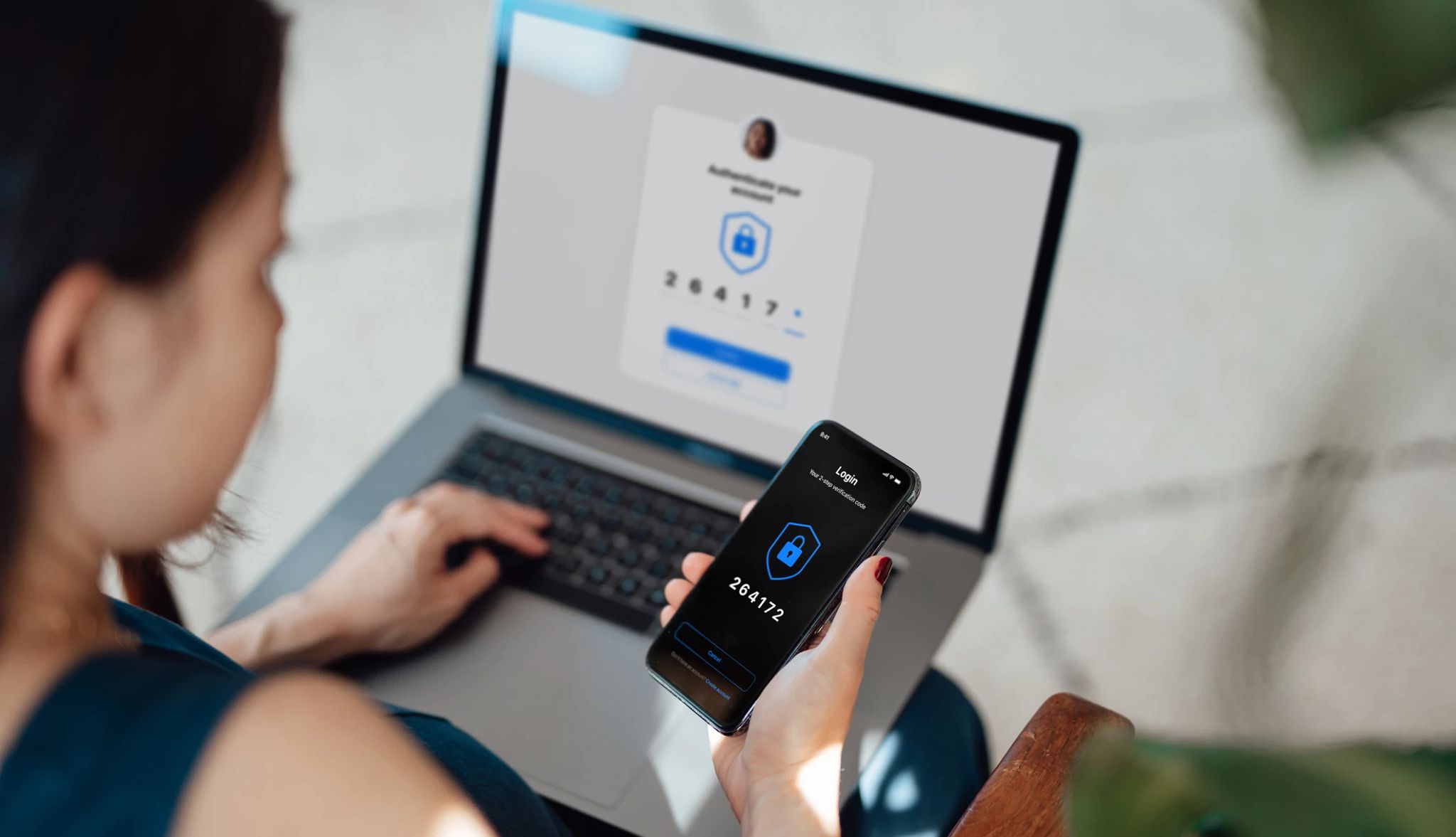 Businesswoman using laptop and mobile phone for two-factor authentication to log in to online banking