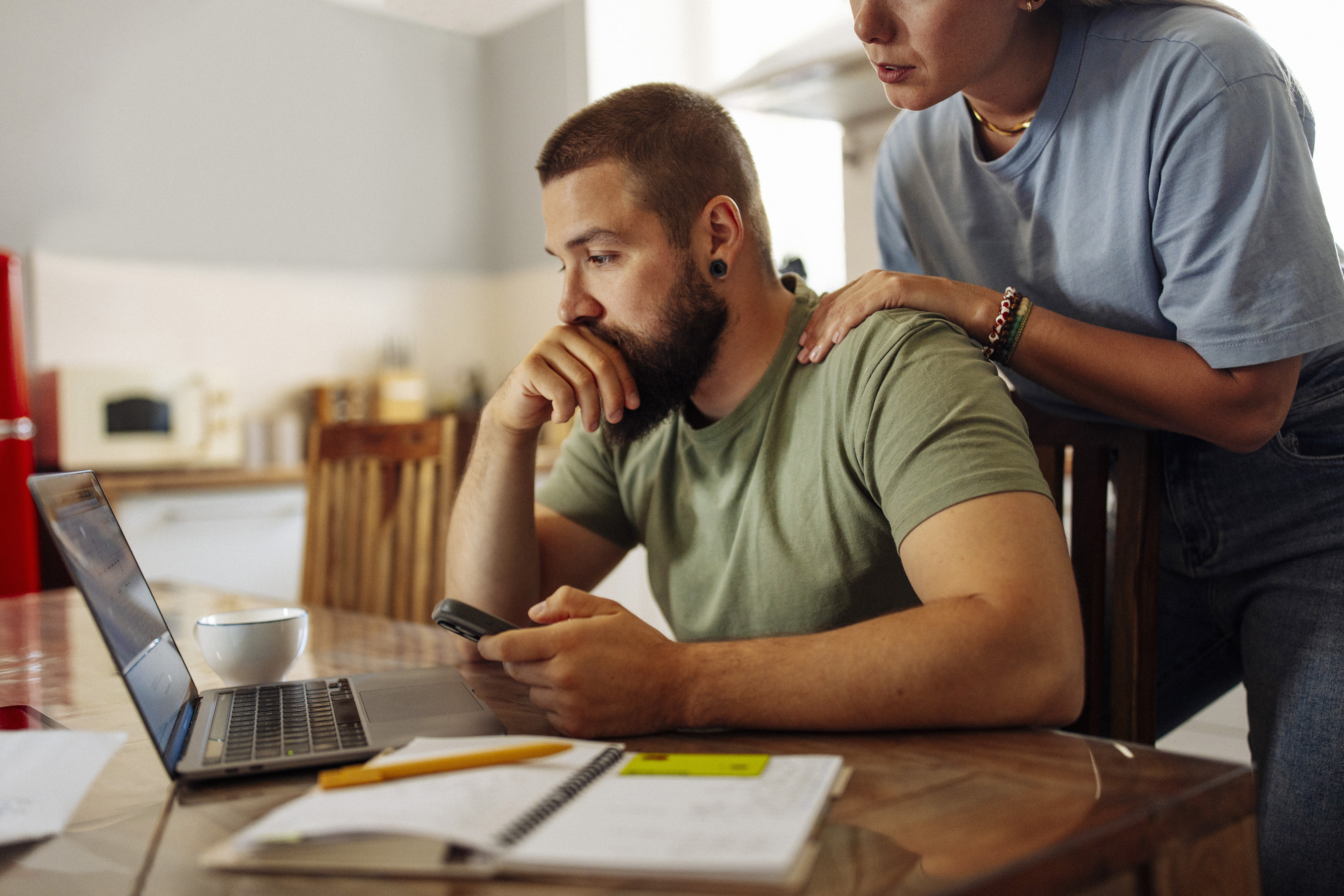 Focused Man Managing Finances on Laptop at Home