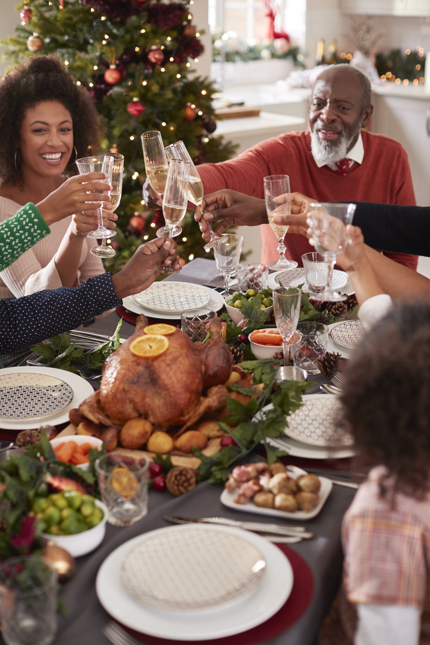 Grandfather making a toast with his family at the Christmas dinner table, elevated view