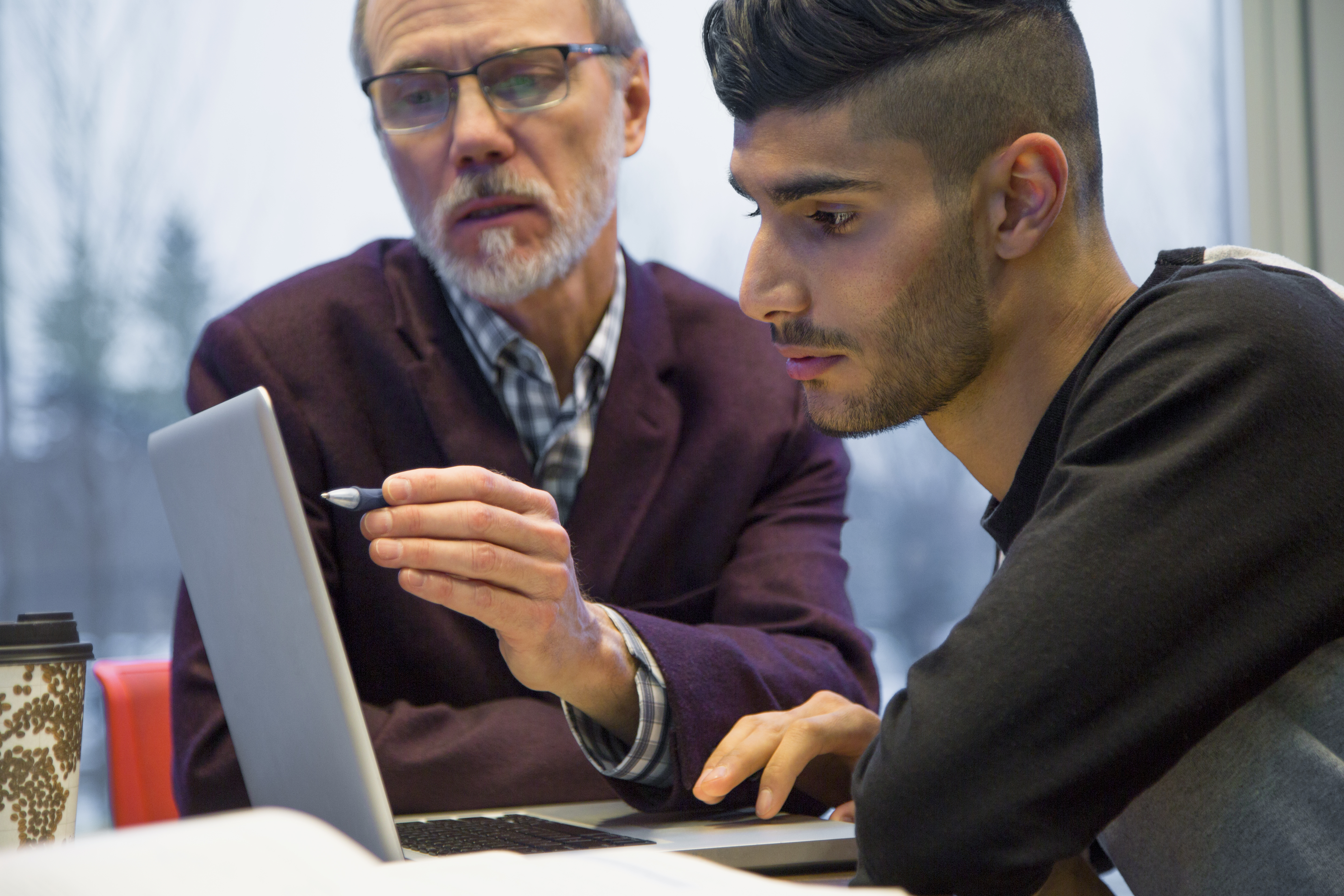 Professor and college student at laptop