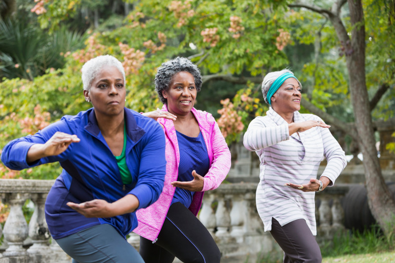 Three senior black women practicing Tai Chi