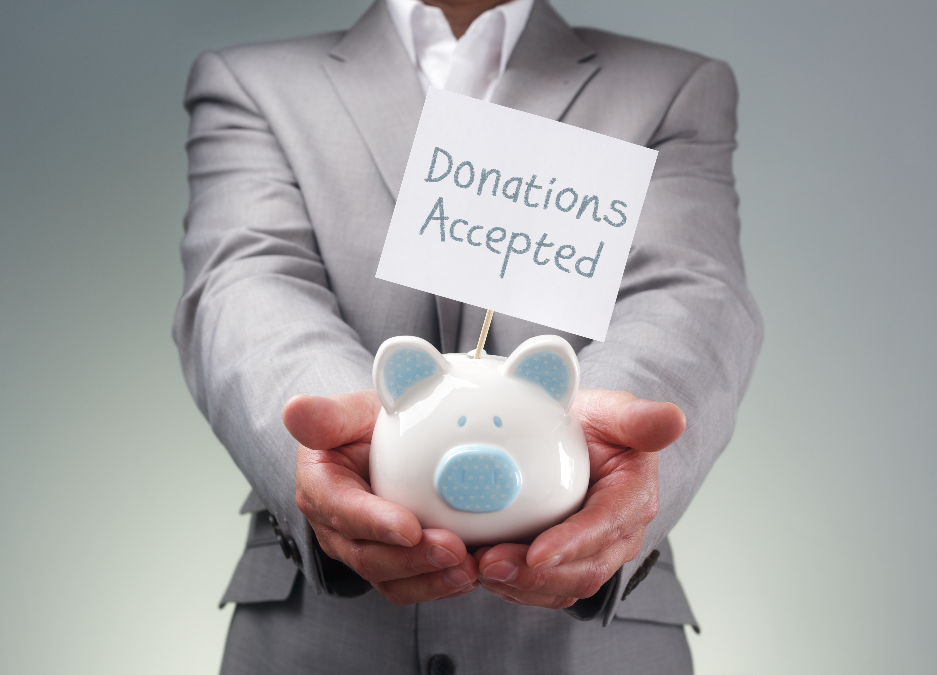 Businessman holding piggy bank for charity