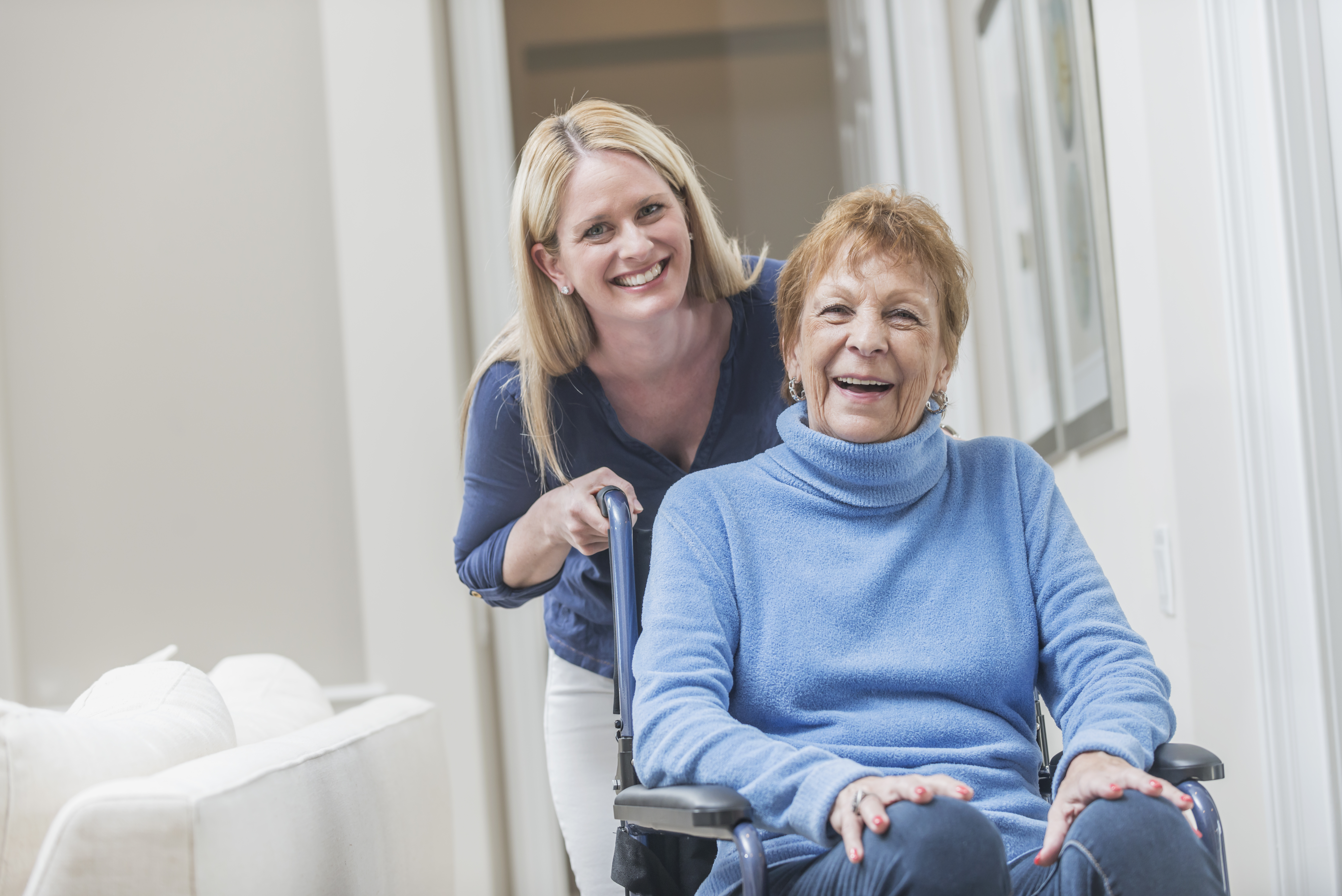 Senior woman in wheelchair with caregiver at home