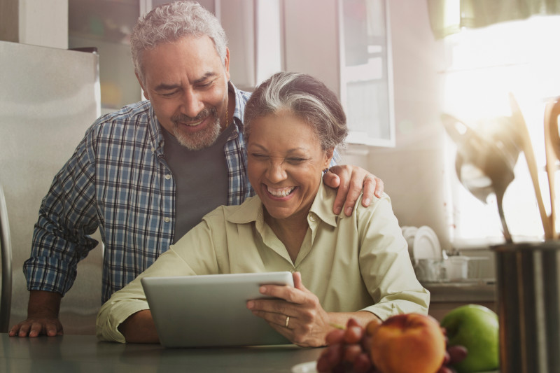 Hispanic couple using digital tablet in kitchen