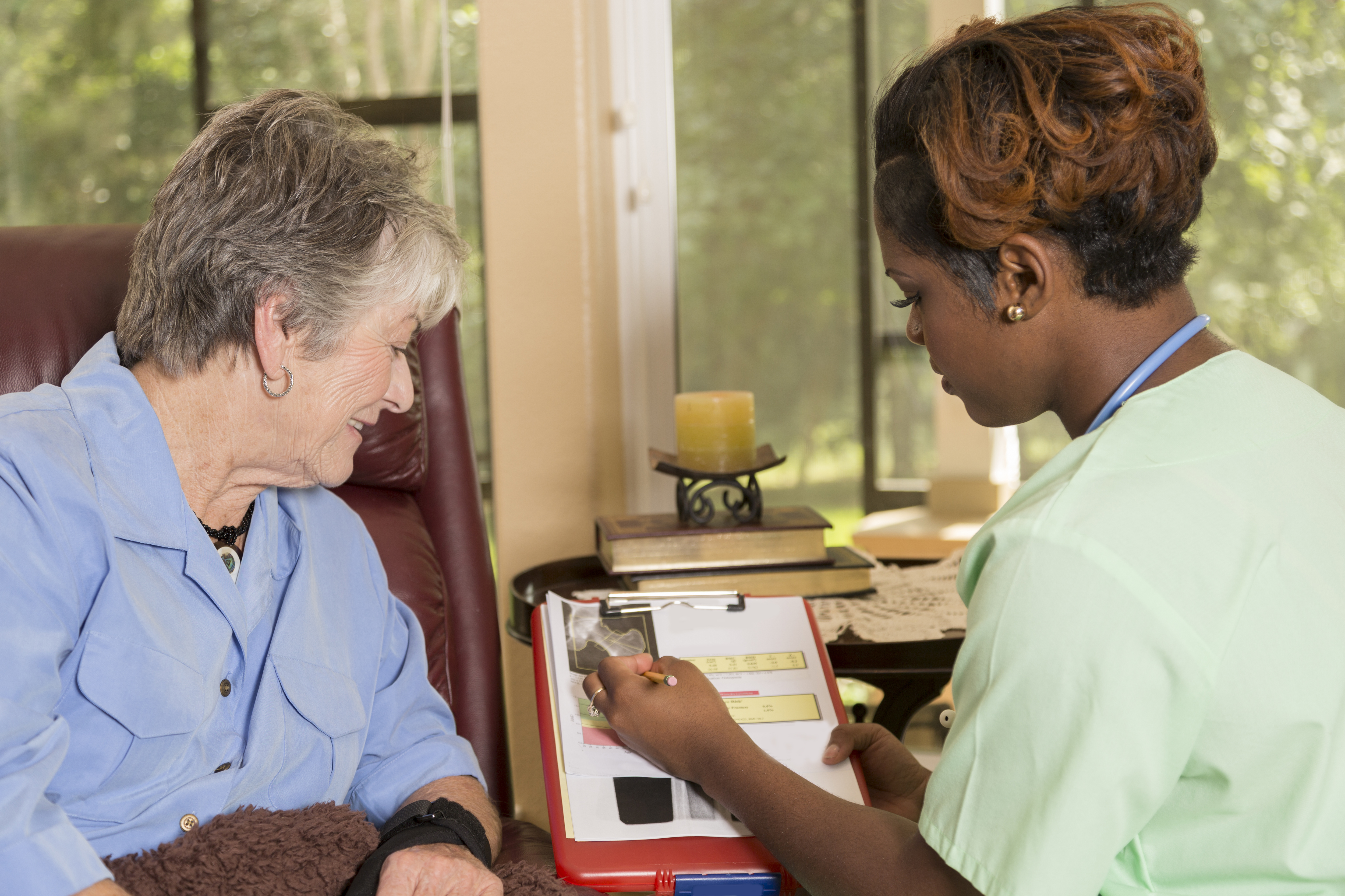 Home healthcare nurse with senior adult patient. Consulation. Medical results.