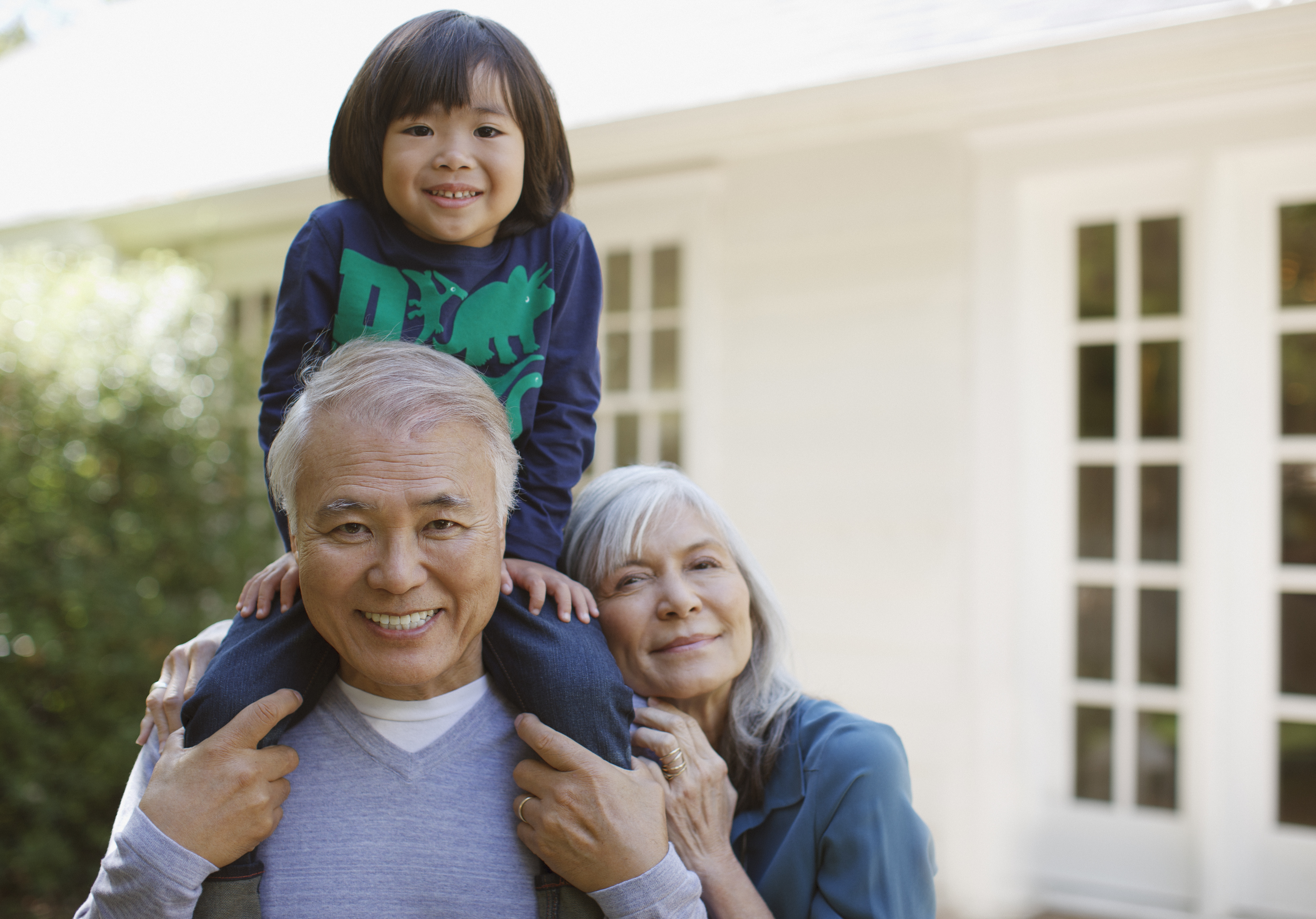 Older couple and grandson standing outdoors