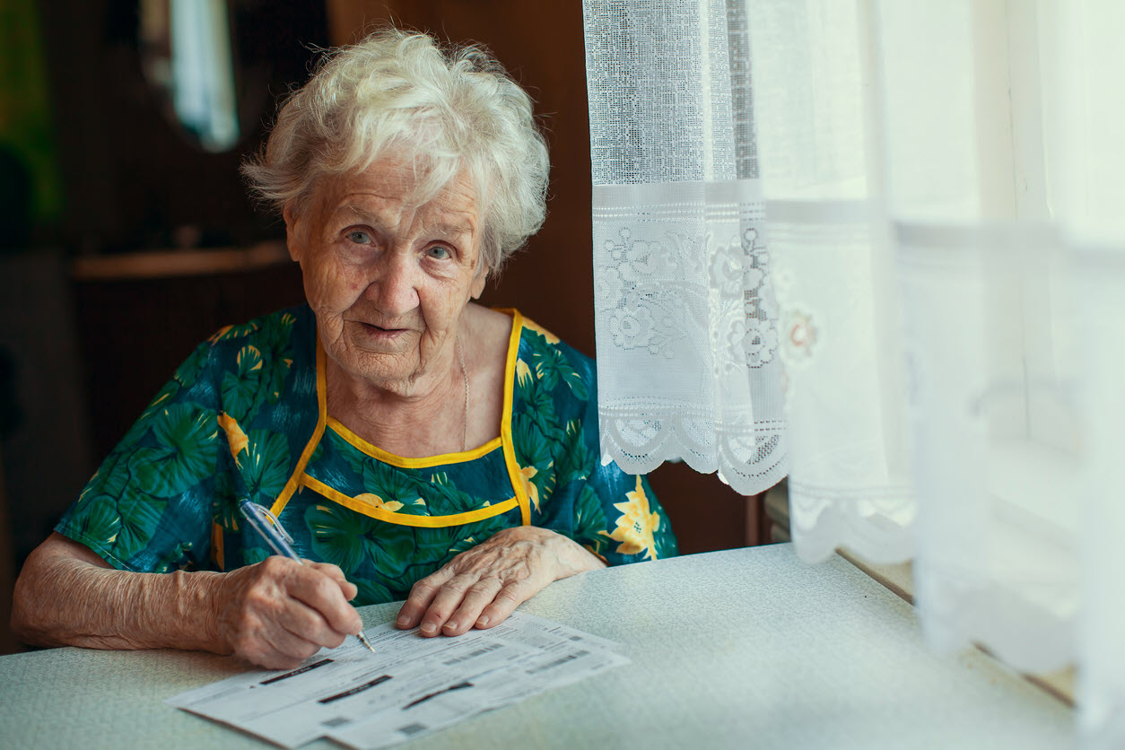 MONEY_elderly woman paying bills_DimaBerkut