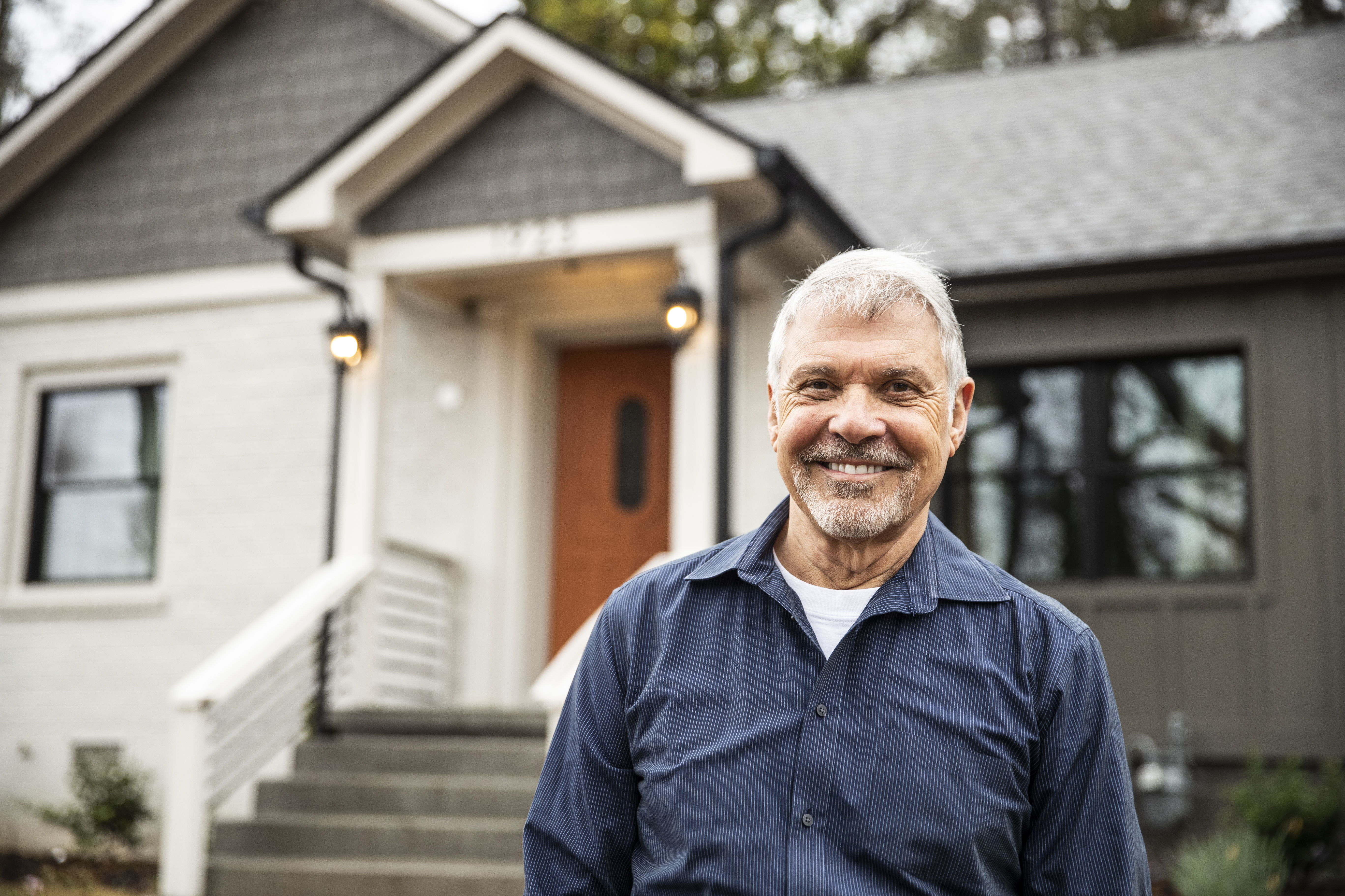 Portrait of senior man in front of home