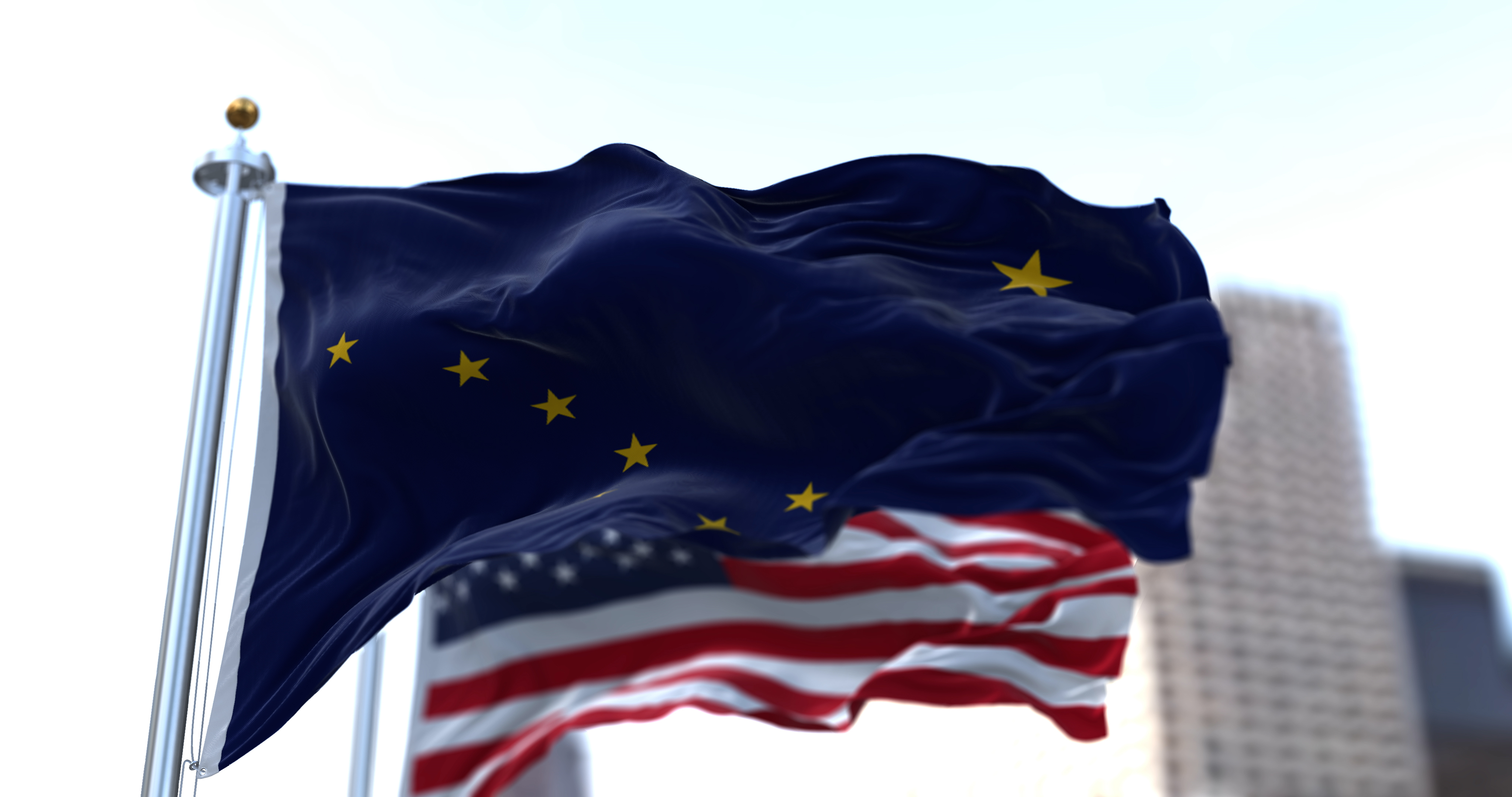 The flags of the Alaska state and United States of America waving in the wind. Democracy and independence. American state. Seamless 3D animation