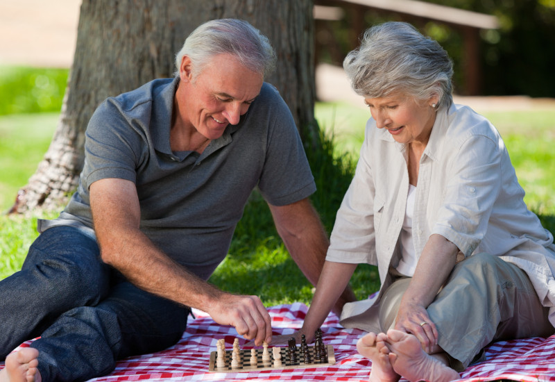 Mature couple playing chess in the garden