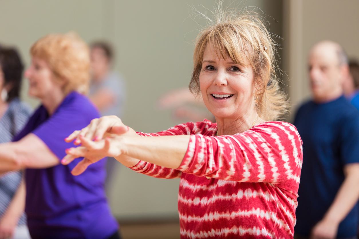 Group of active seniors exercise in yoga class.