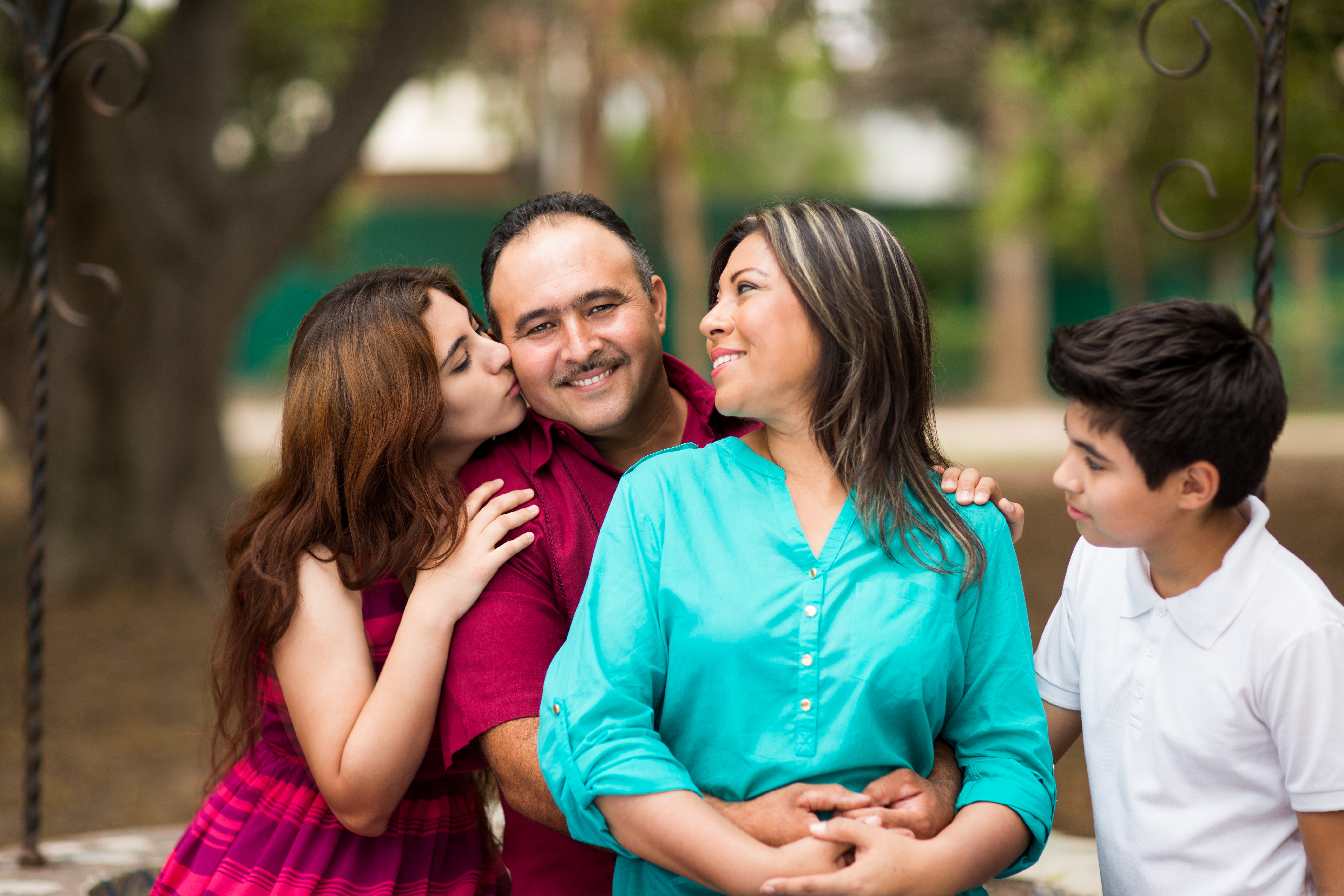 Latin family of four showing affection