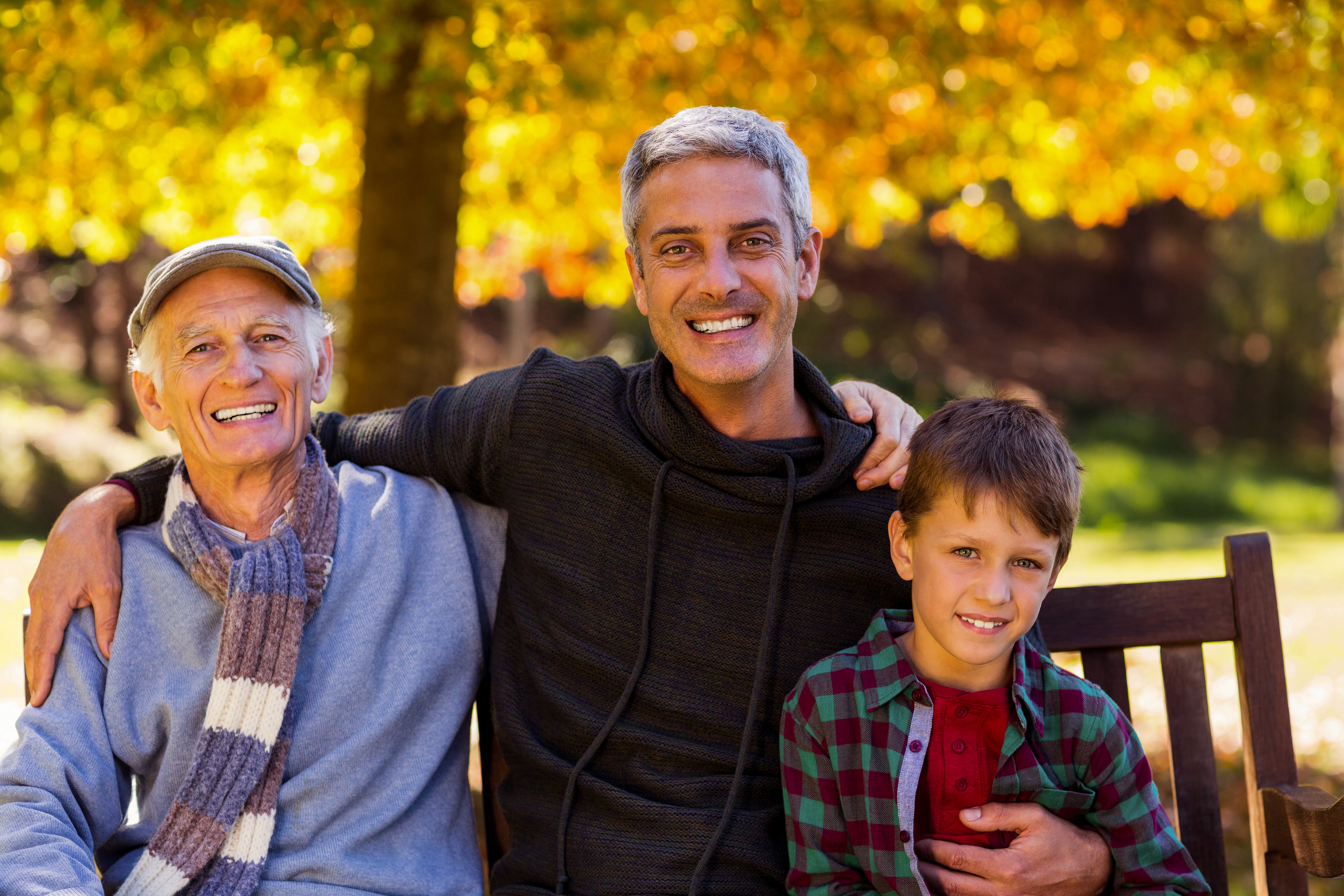 Man with father and son sitting at park