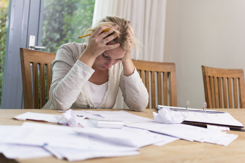 Exasperated woman at desk with paperwork_mactrunk_499.997