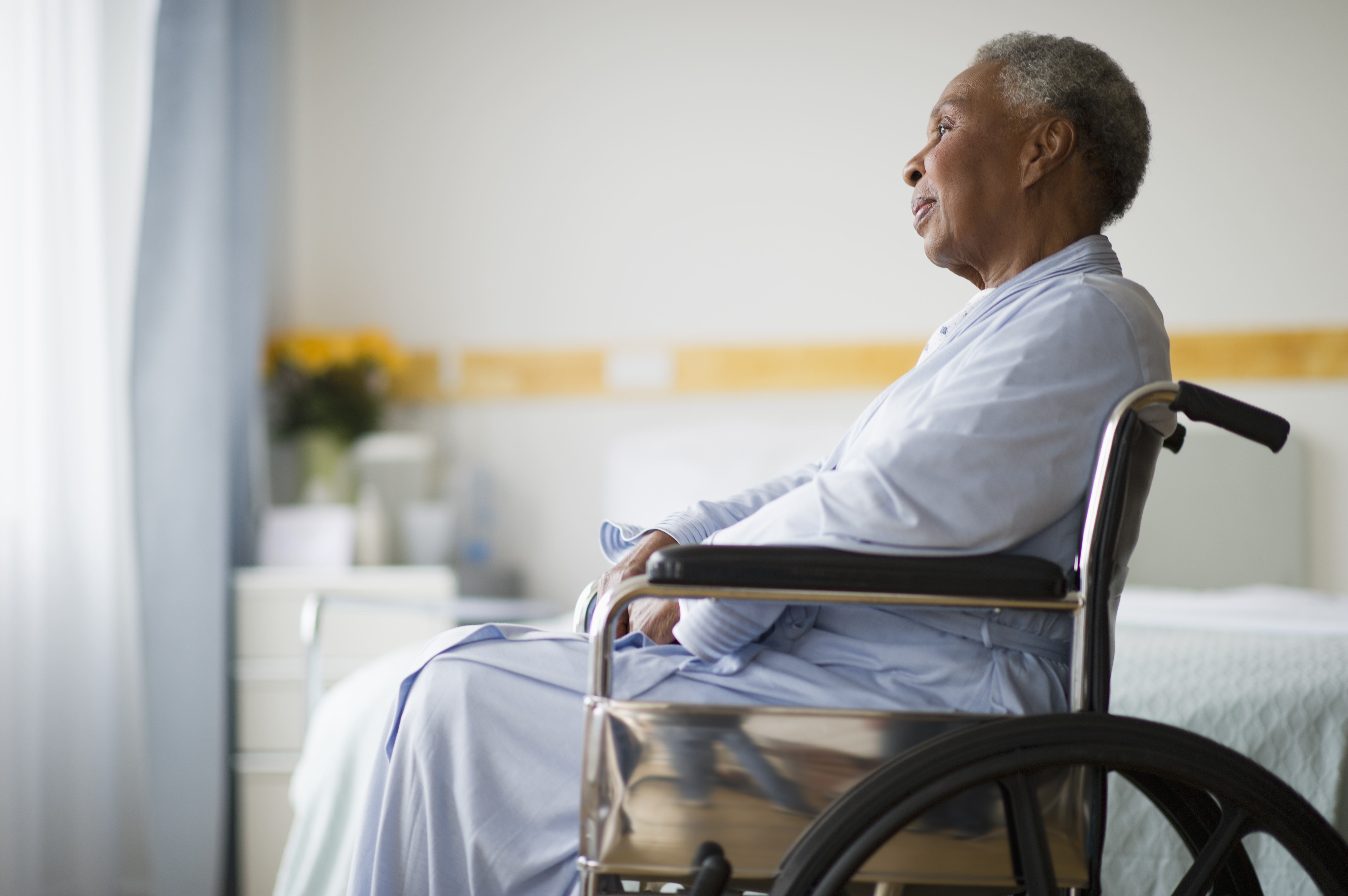 Black woman sitting in wheelchair in  hospital