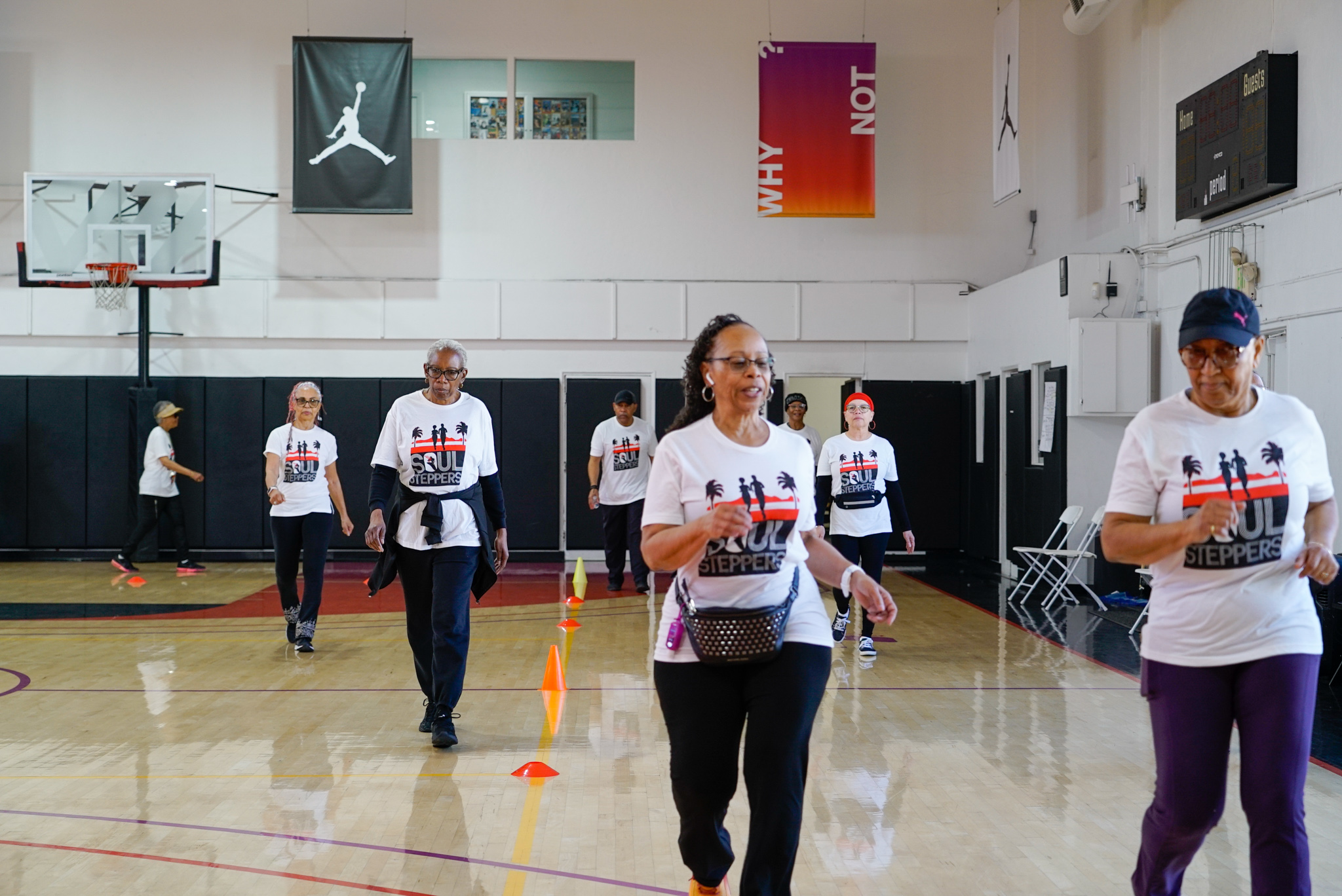 Group of older adults walking in a gym