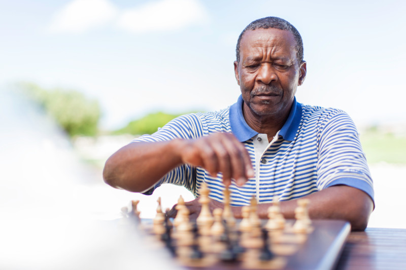 African American senior making his move in a game of chess