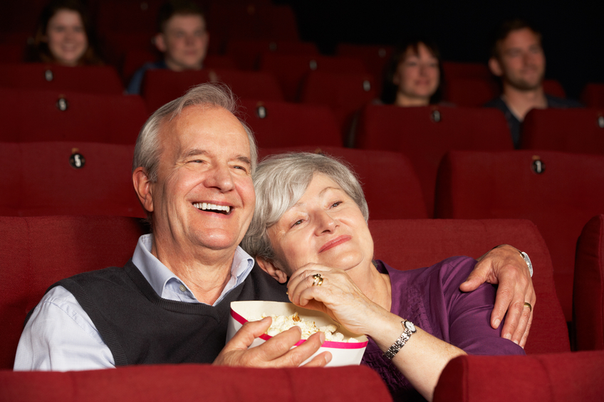 Senior Couple Watching Film In Cinema