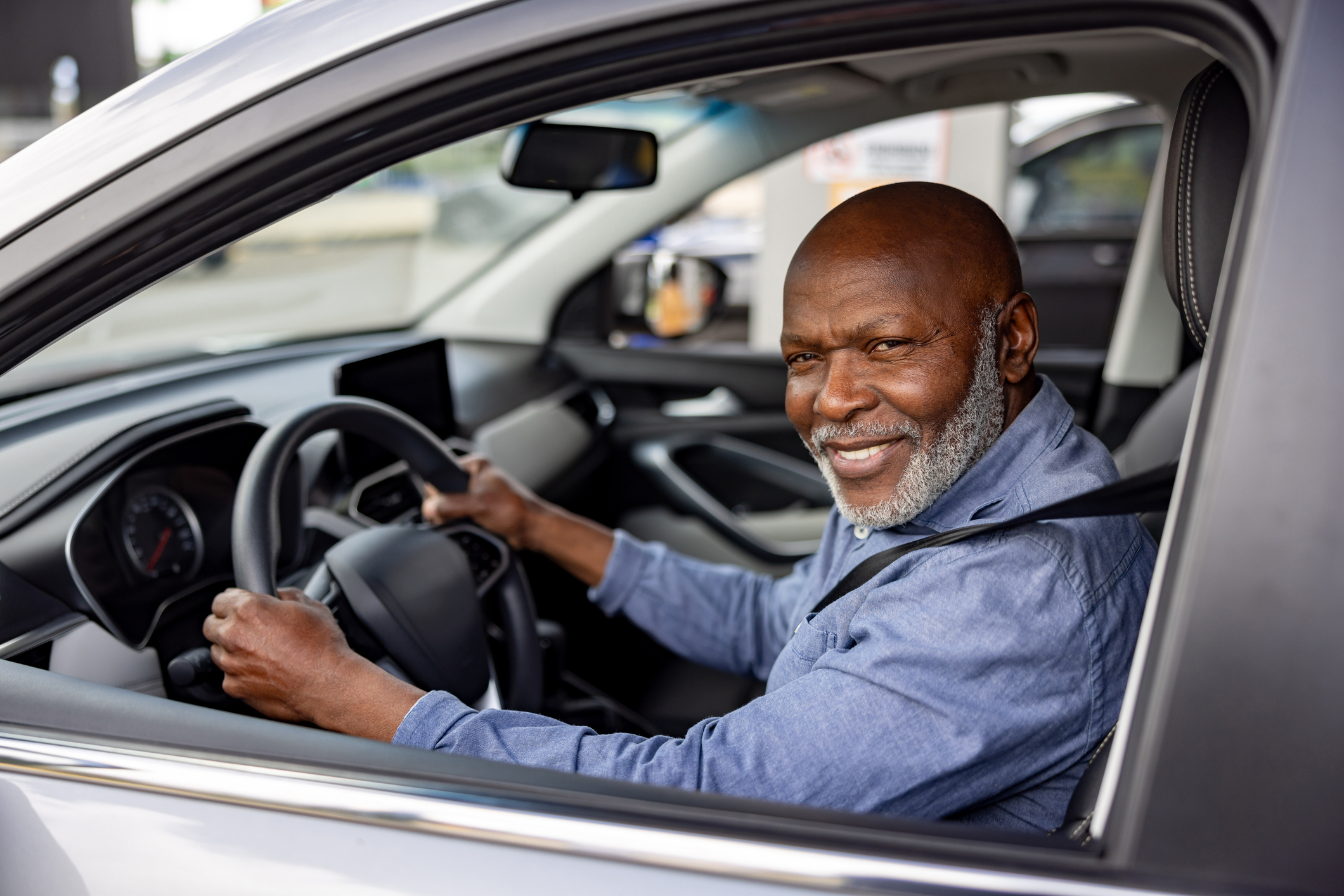 Crowdsourced taxi driver smiling in his car