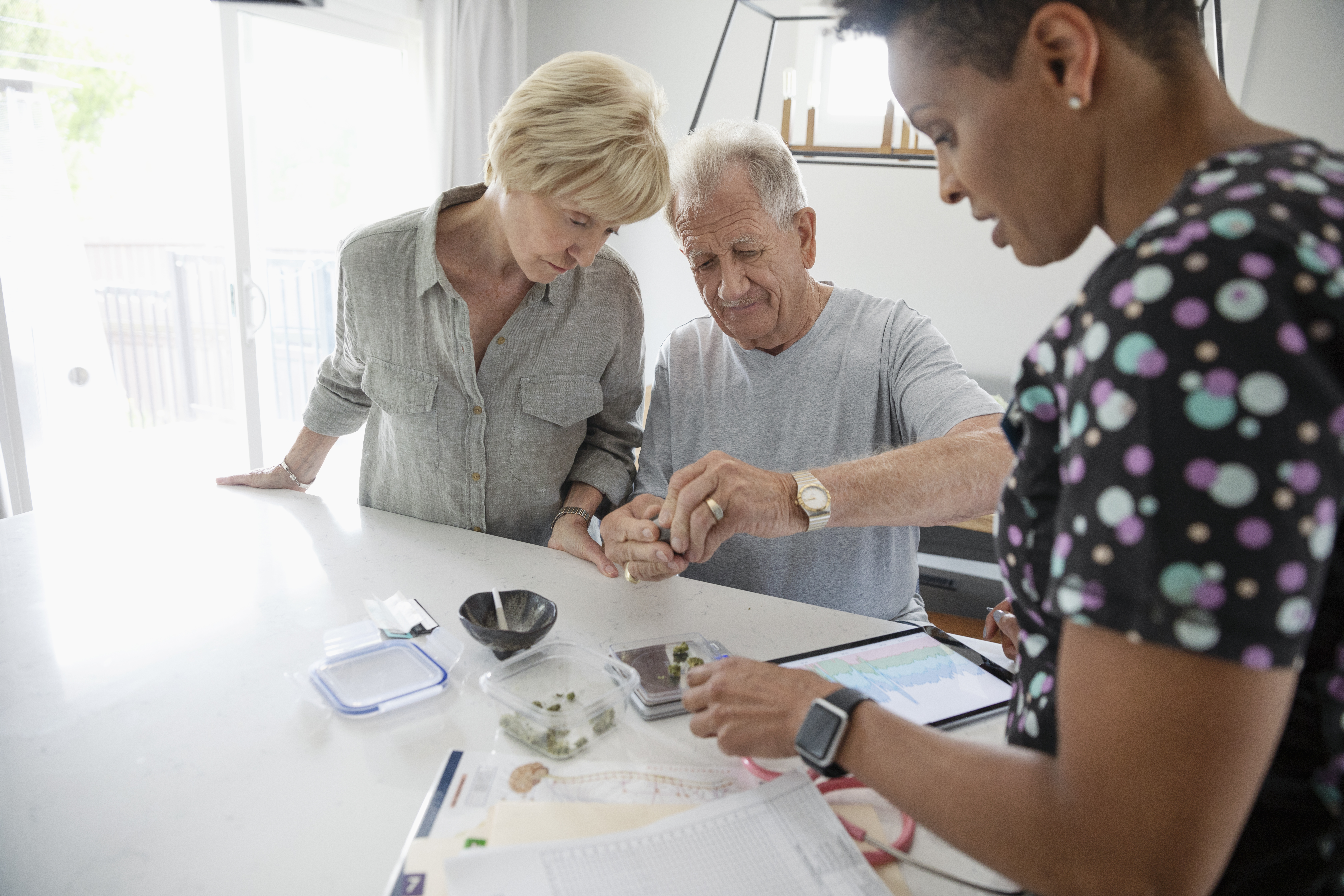 Home healthcare nurse helping senior couple with medical marijuana