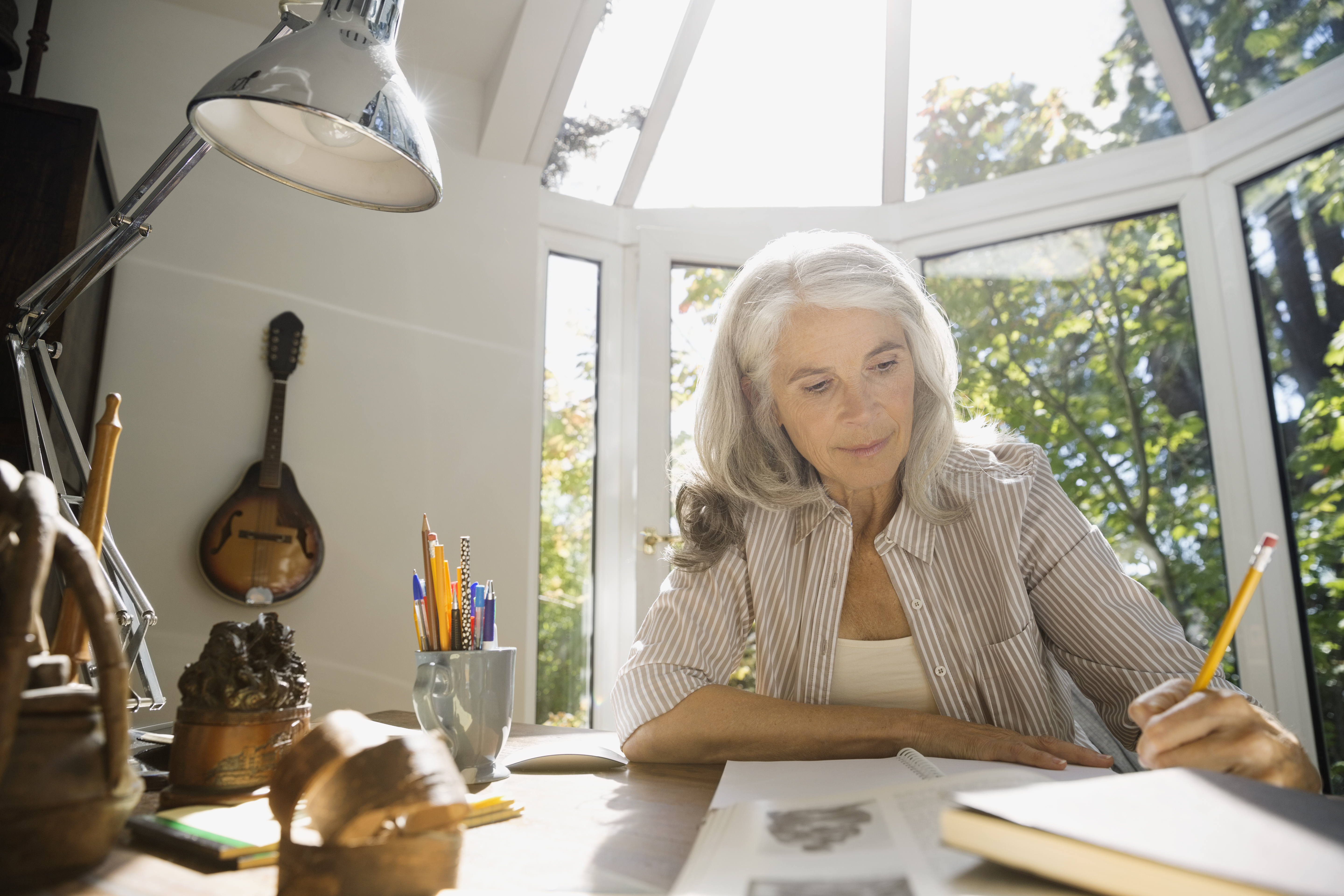 Senior woman writing in home office