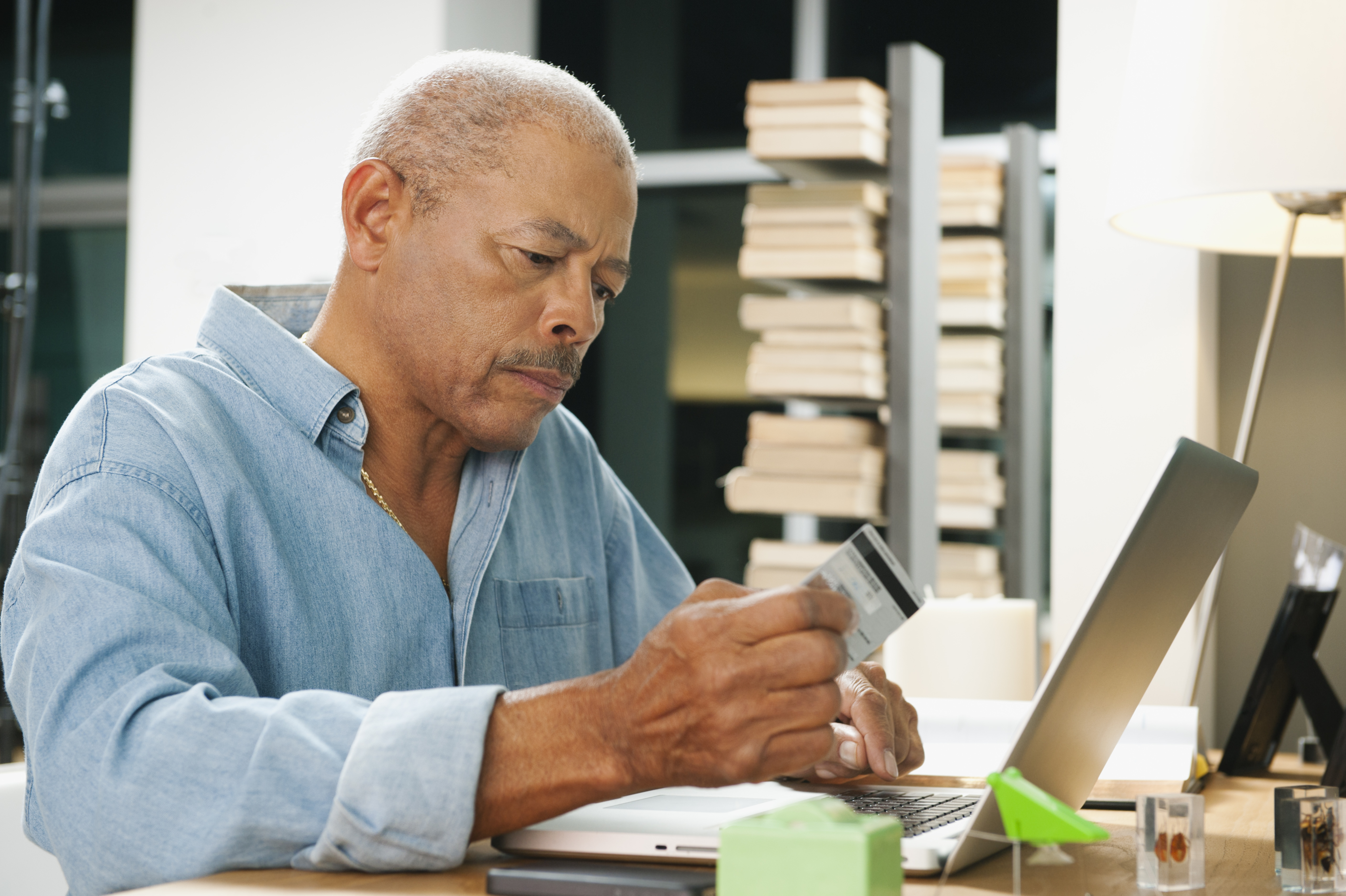 Black man shopping on line with credit card