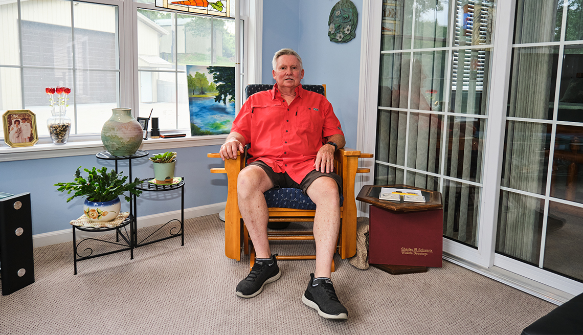 A man sits in a chair in his home