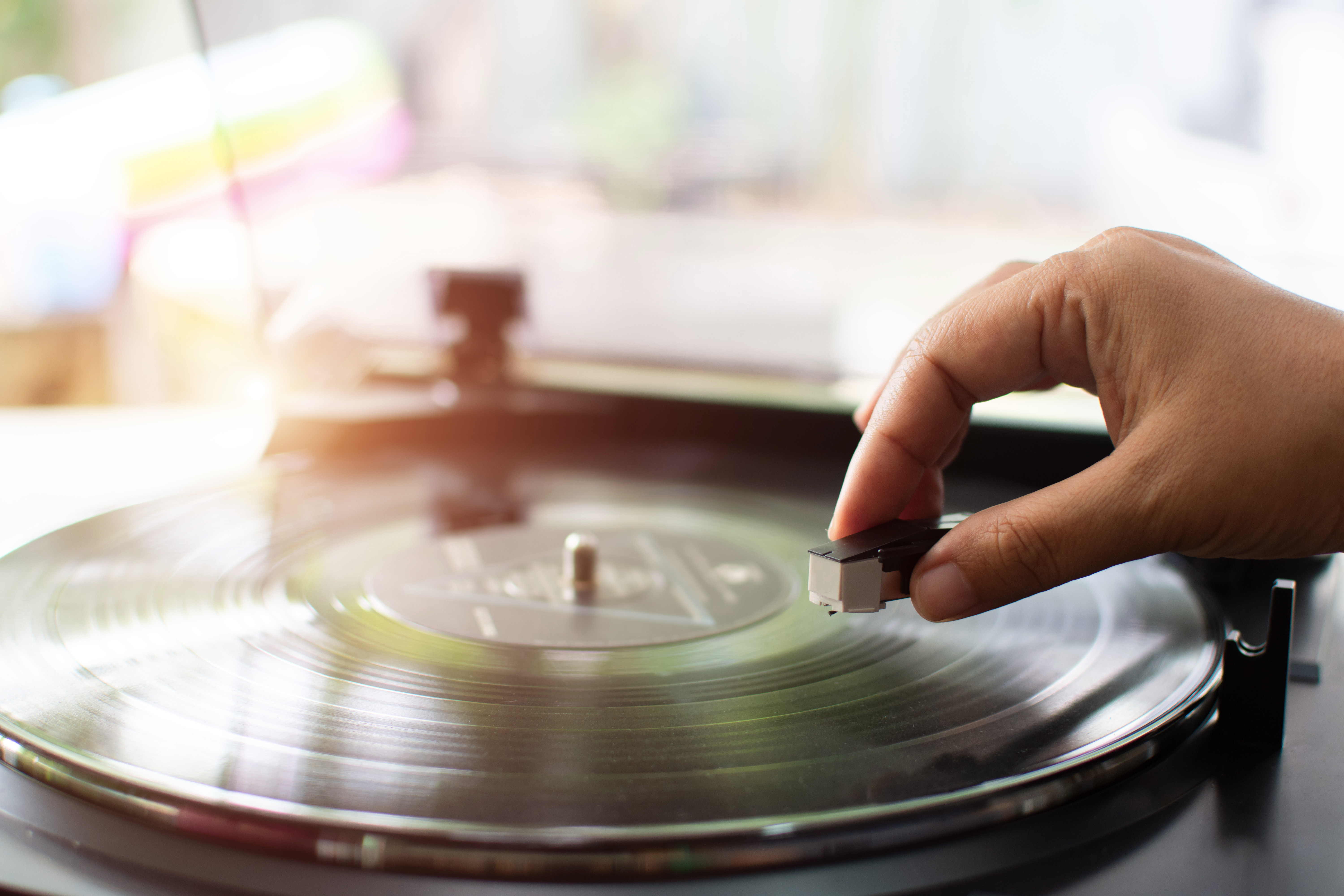 Vinyl record player, bright lights disco-bokeh. Needle on vinyl record.