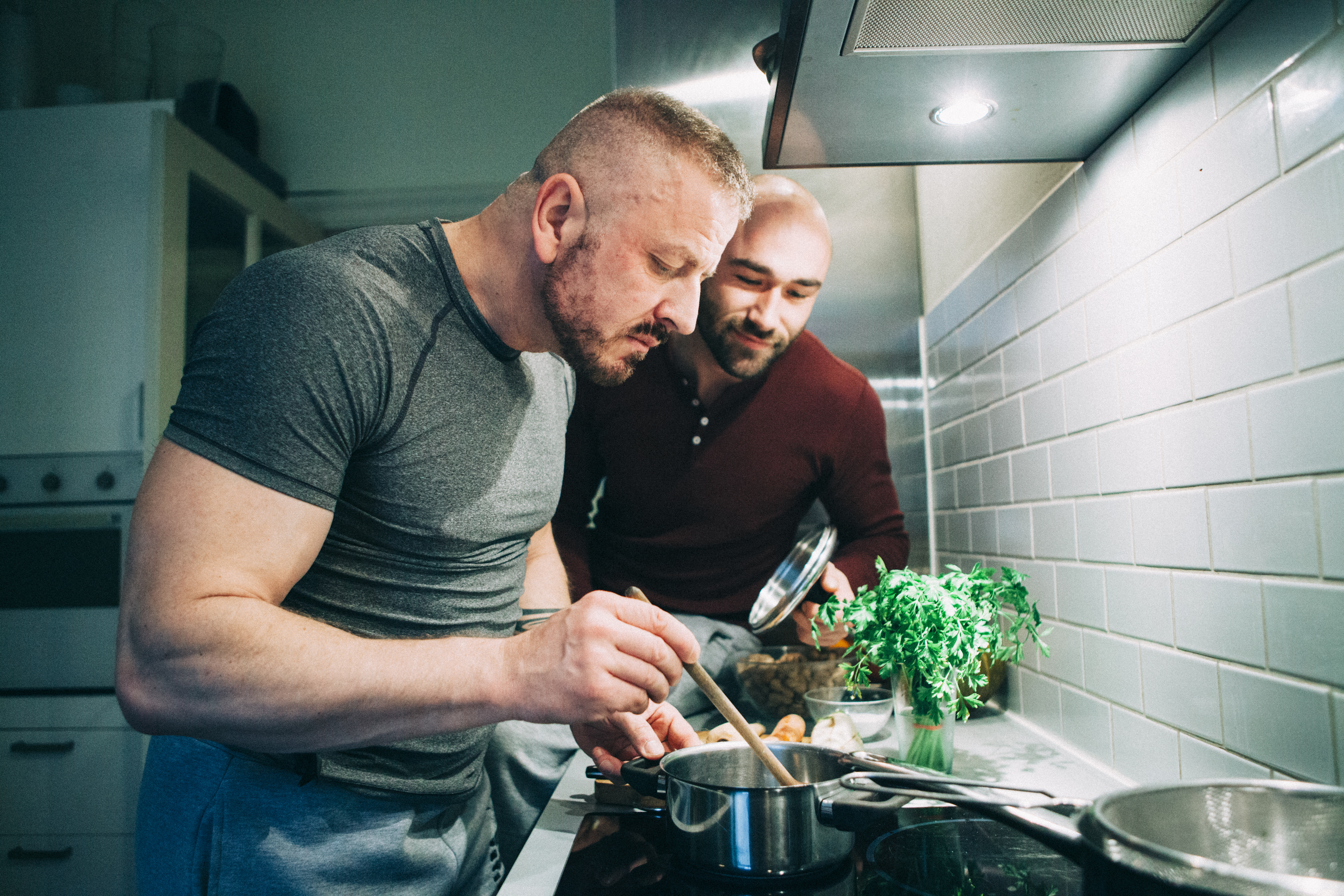 gay couple preparing the meal in the kitchen
