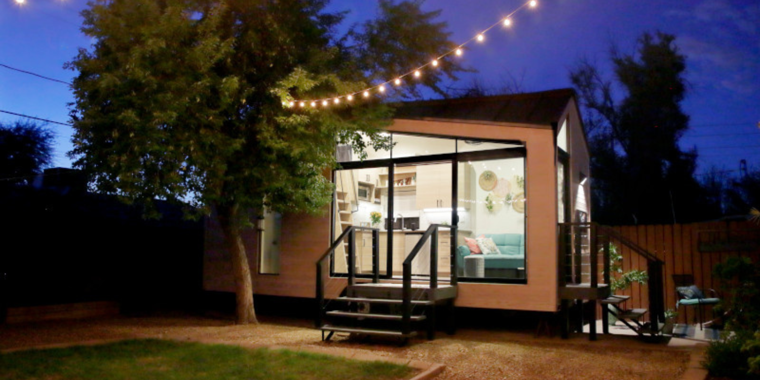 A backyard accessory dwelling unit is seen at night with lights.