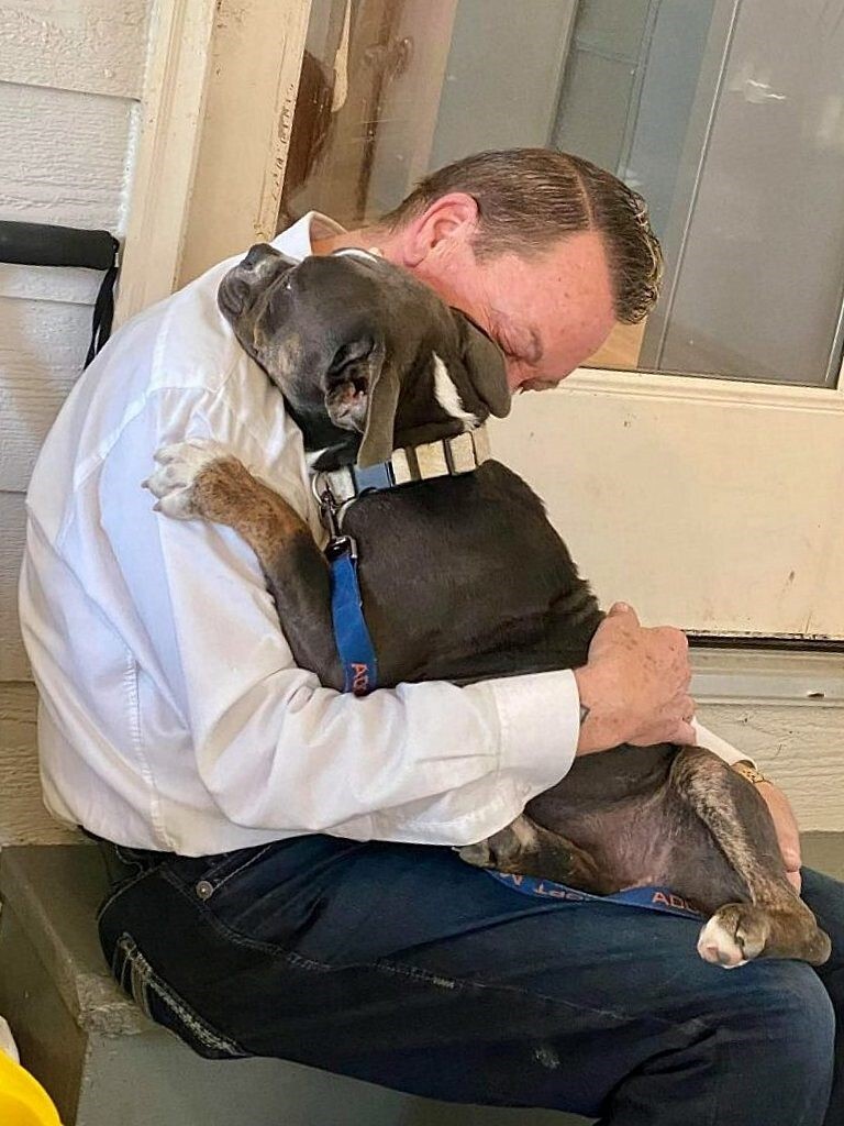man hugging a dog