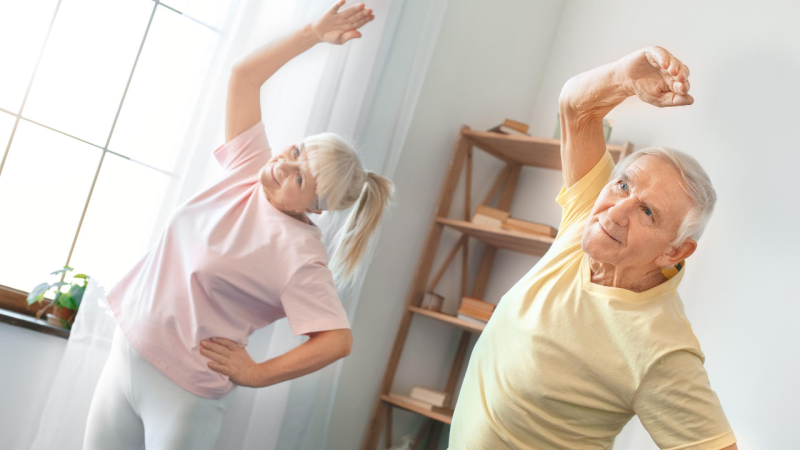 couple stand stretching at home.png