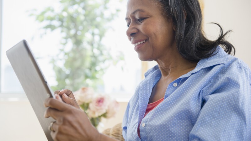 Mixed race woman using tablet computer on sofa