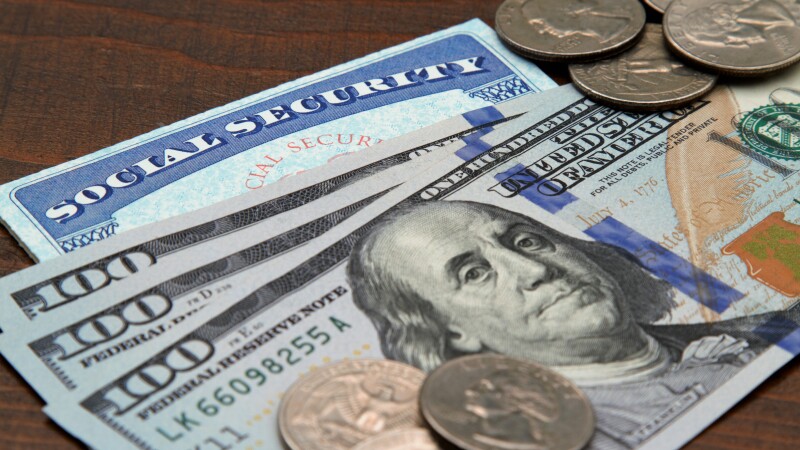 Social security card with USA currency and coins