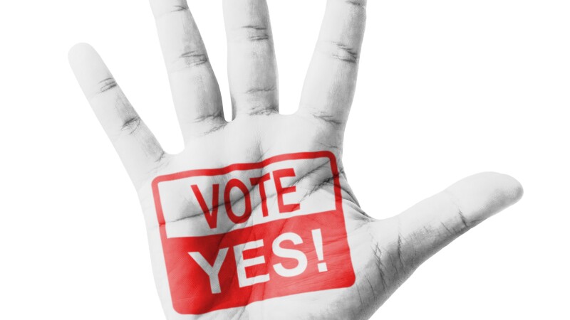 Open hand raised, Vote Yes sign painted