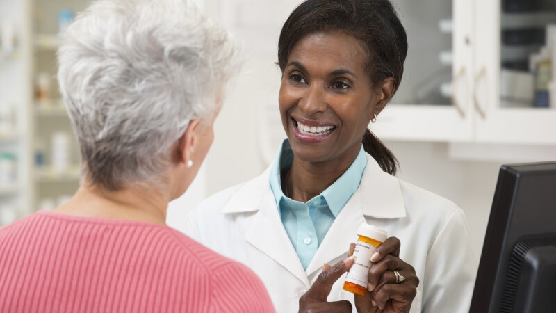 Pharmacist serving customer in pharmacy