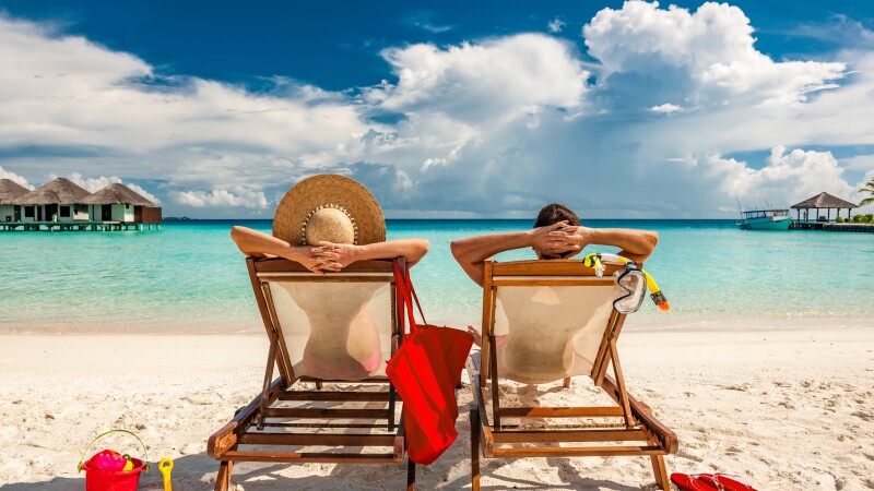 Couple in loungers on beach at Maldives