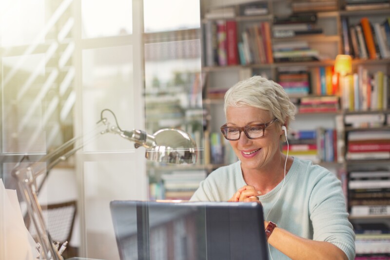 Businesswoman listening to earbuds and working in home office
