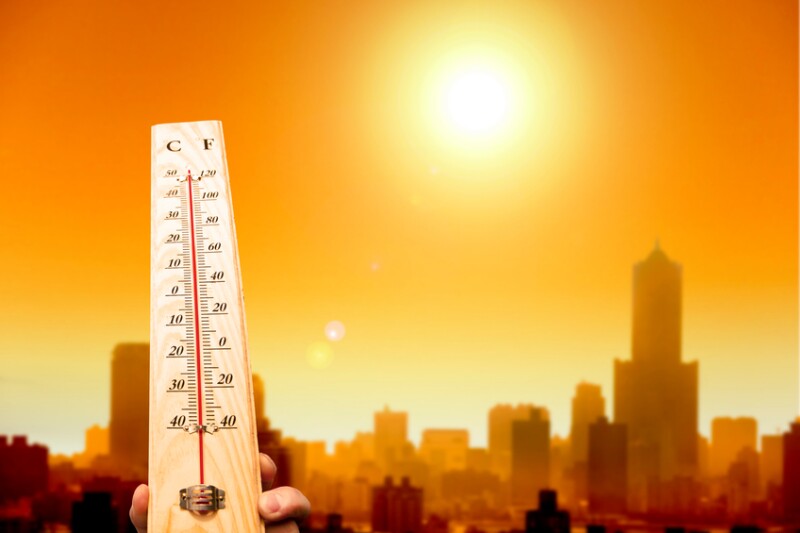 heat wave in the city and hand showing thermometer