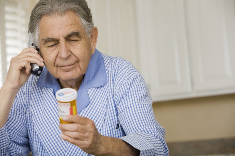 Senior man reading medication bottle